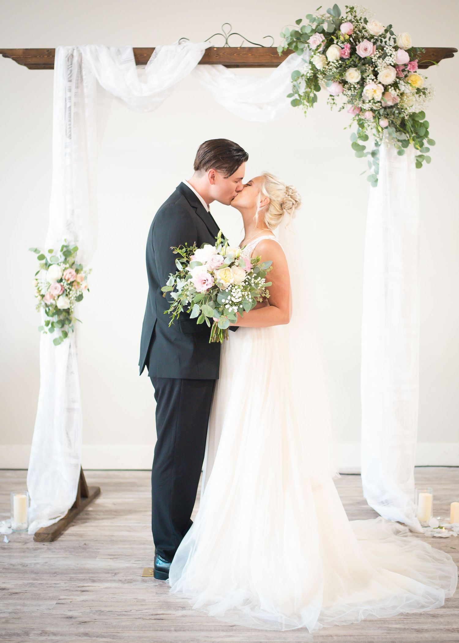 Bride and groom sharing a romantic first dance beneath elegant wedding décor at their reception.