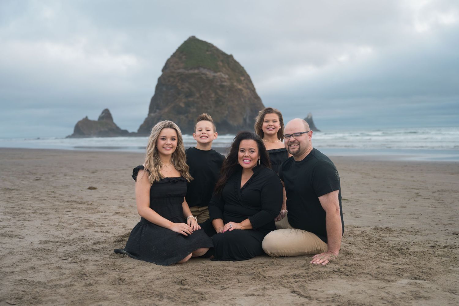 Family portrait on the Oregon Coast with iconic Haystack Rock and beautiful ocean scenery.