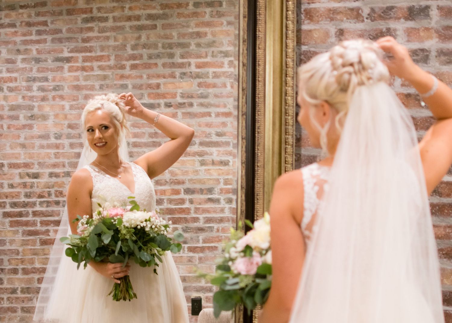 Bride admiring her reflection while adjusting her veil before the wedding ceremony.