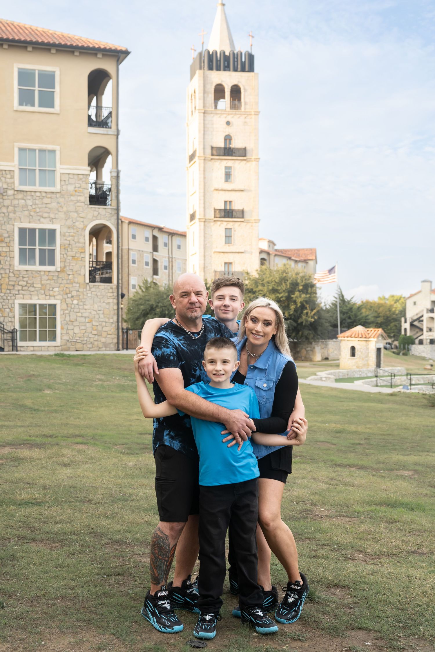 Family of four smiling together during an outdoor family photography session in Texas.