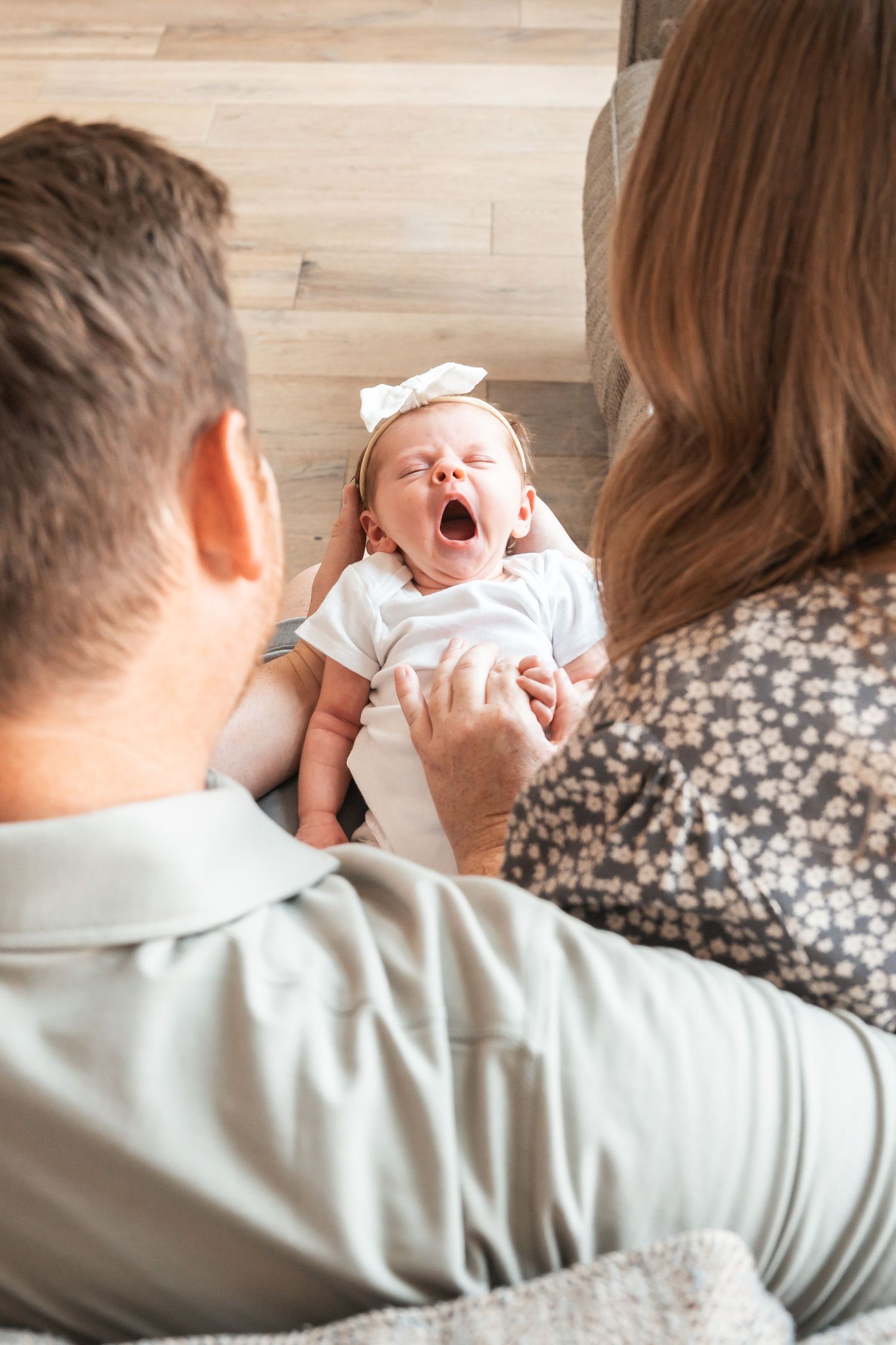 Parents admiring their newborn baby during a natural lifestyle newborn photography session.