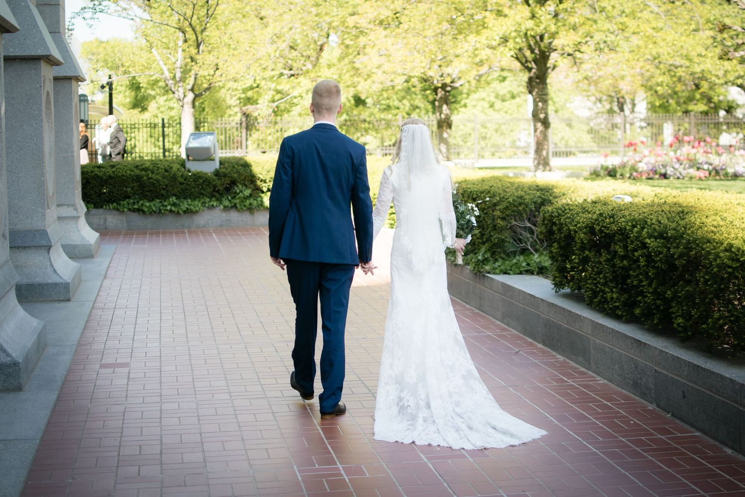 Bride and groom walking together outside the LDS temple after their wedding ceremony.