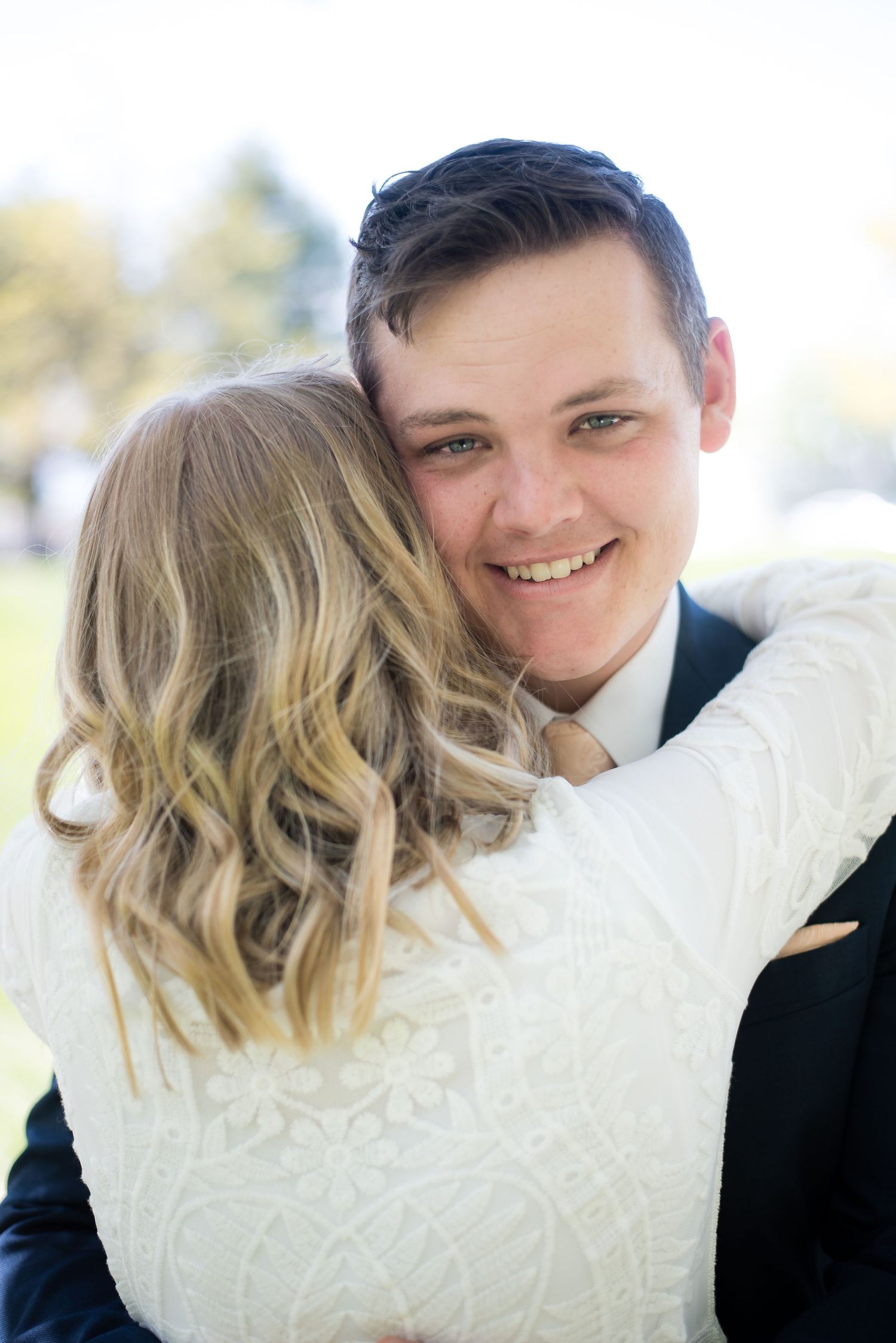Bride and groom sharing a joyful embrace during their wedding day portrait session.