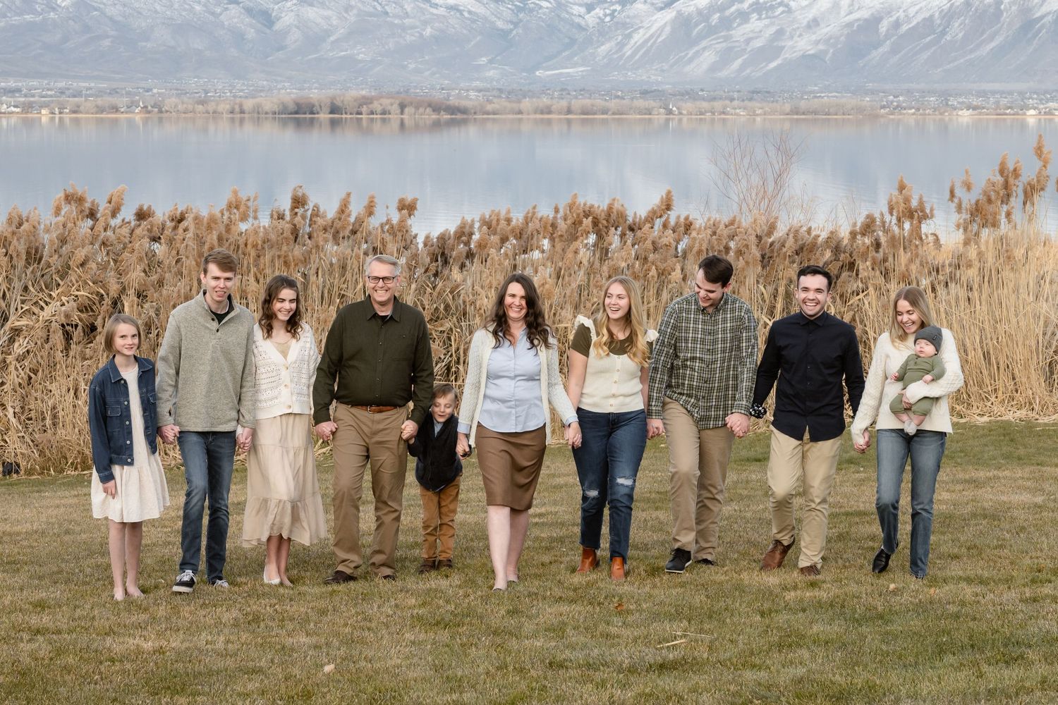 Extended family gathered together near the lake for a scenic outdoor family photography session with Utah mountain views.