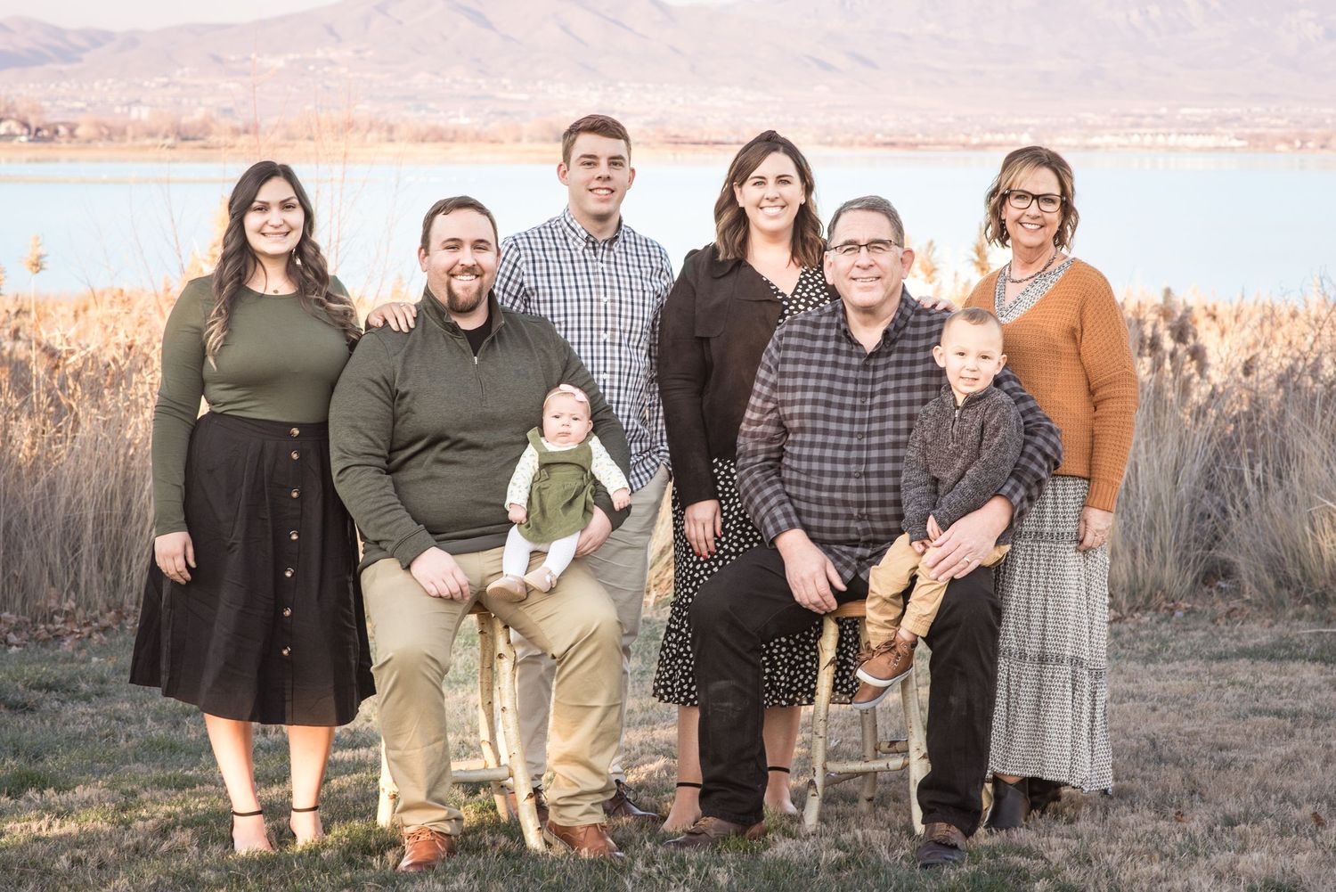 Multi-generational family portrait captured during golden hour with scenic lake views.
