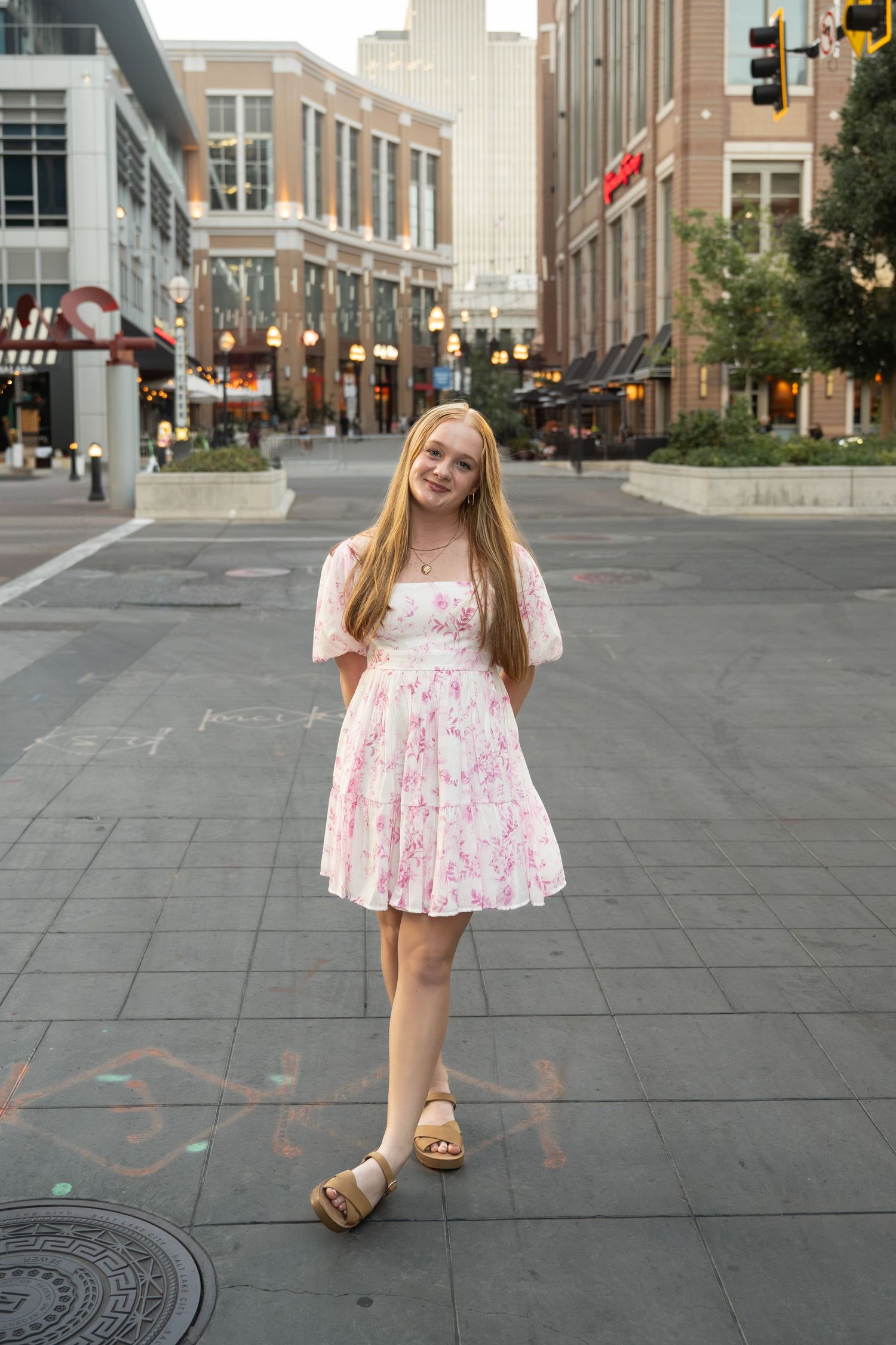 Natural light senior portrait in a downtown city setting with modern architecture.