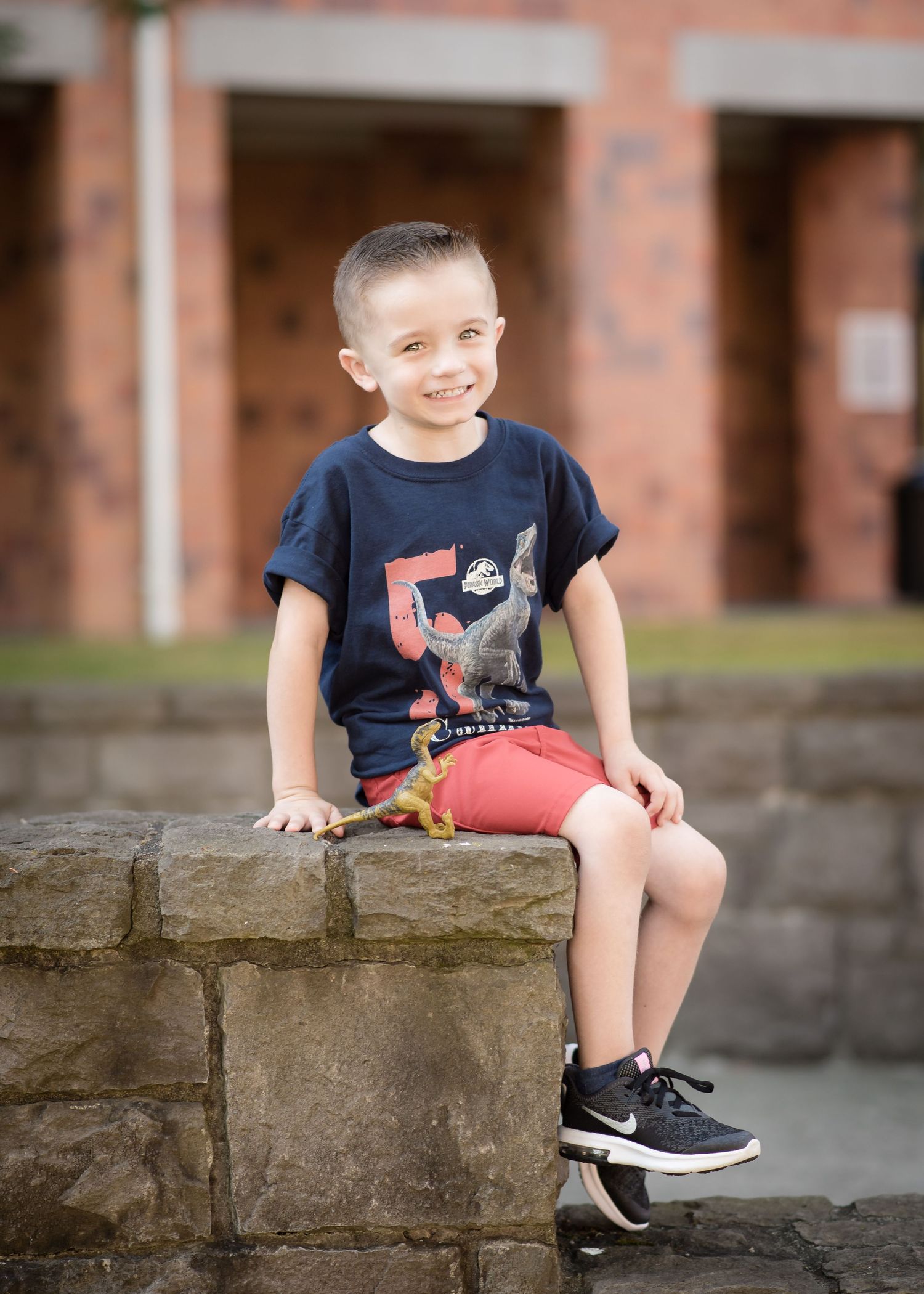 Natural light portrait of a young child sitting outdoors during a family photography session.