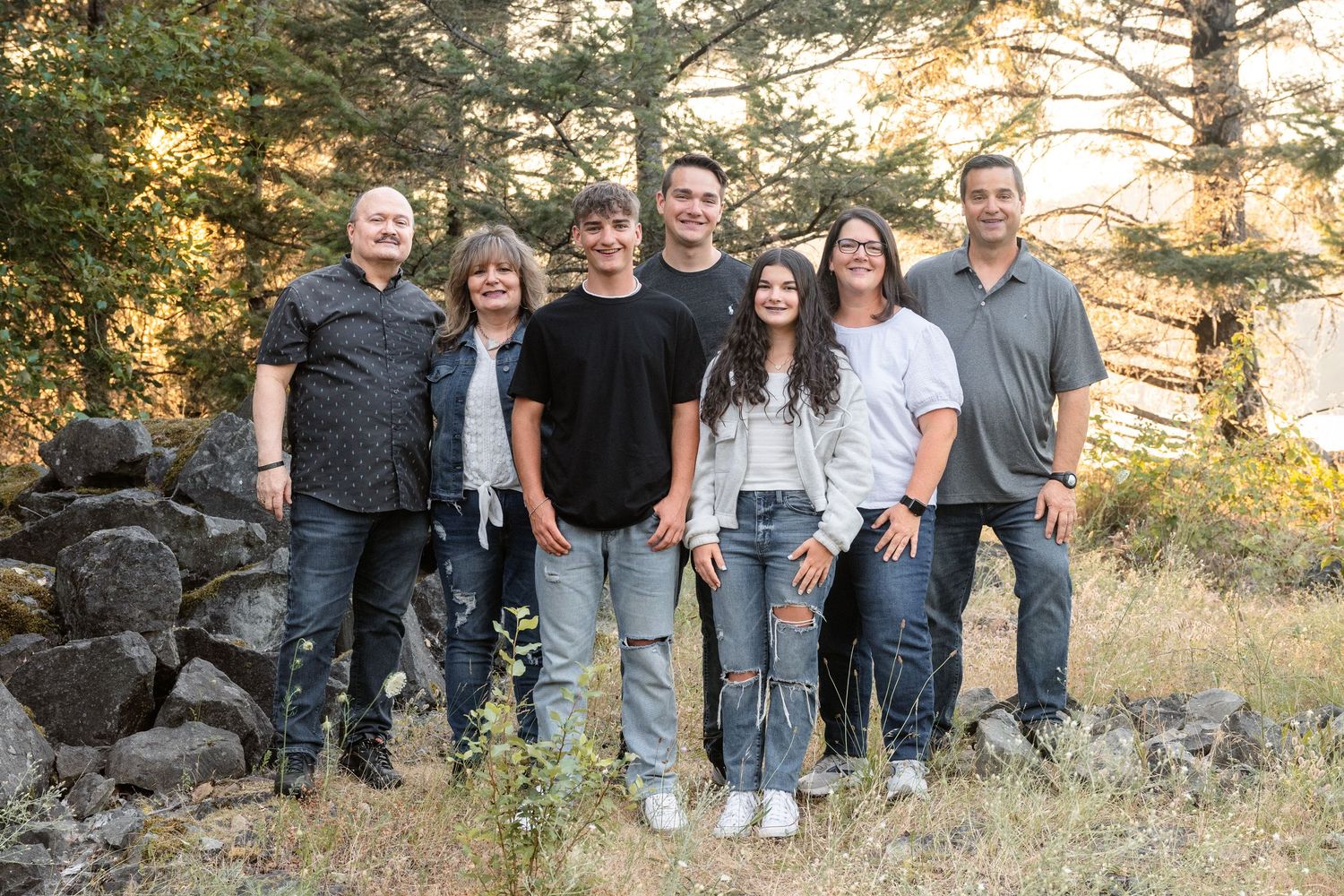 Family portrait surrounded by beautiful trees during a warm outdoor family photography session.