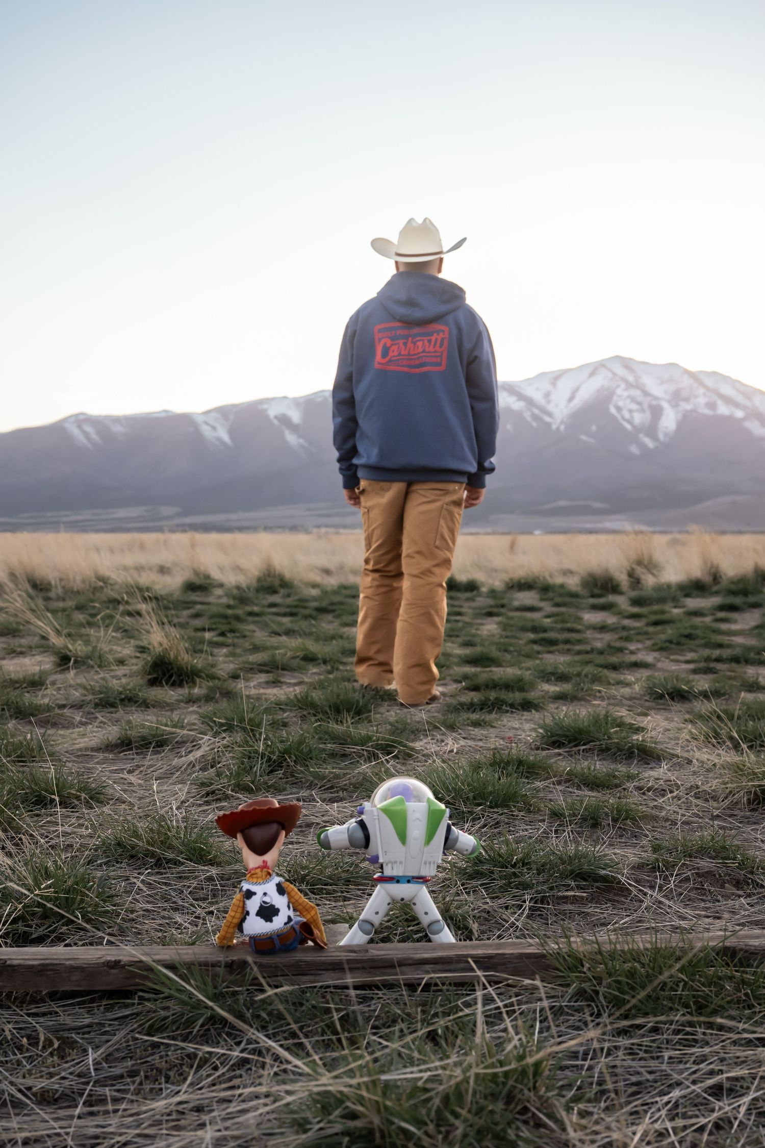 Natural light portrait featuring a young man and his Toy Story action figures with scenic mountain views.