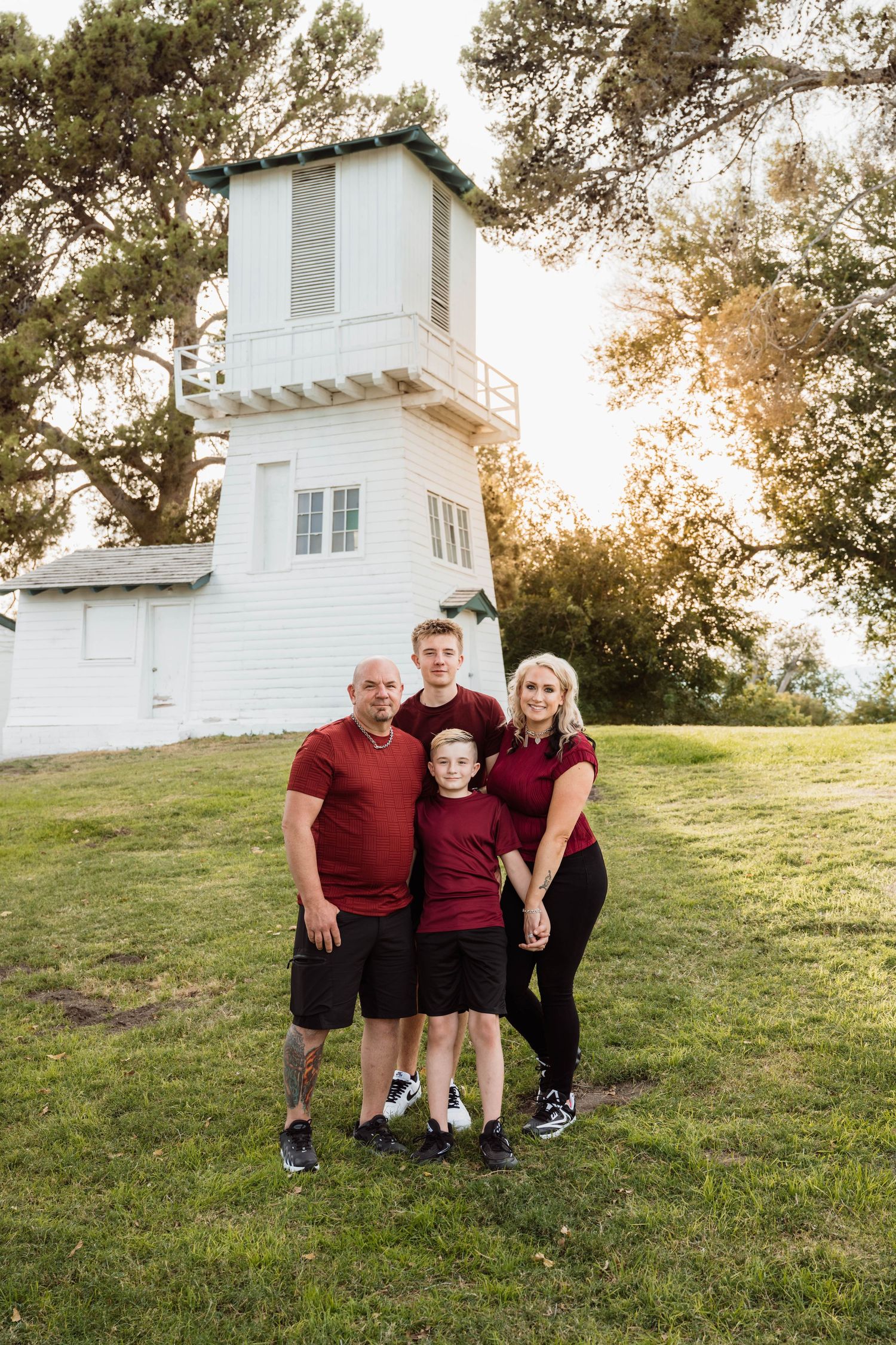 Family gathered together outdoors near a historic white chapel during a natural family photography session.
