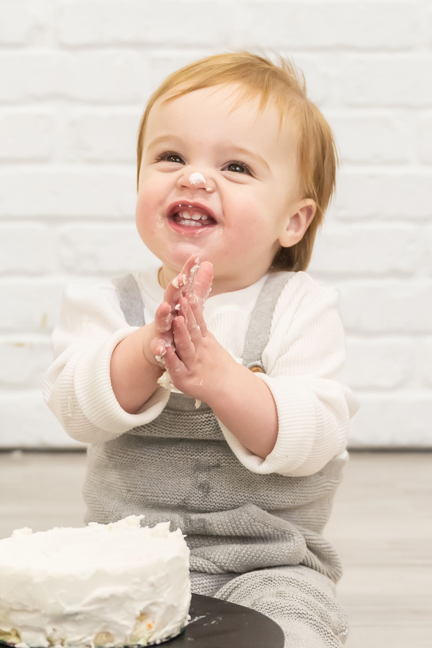 Sweet baby portrait capturing a joyful milestone moment in a bright indoor setting.