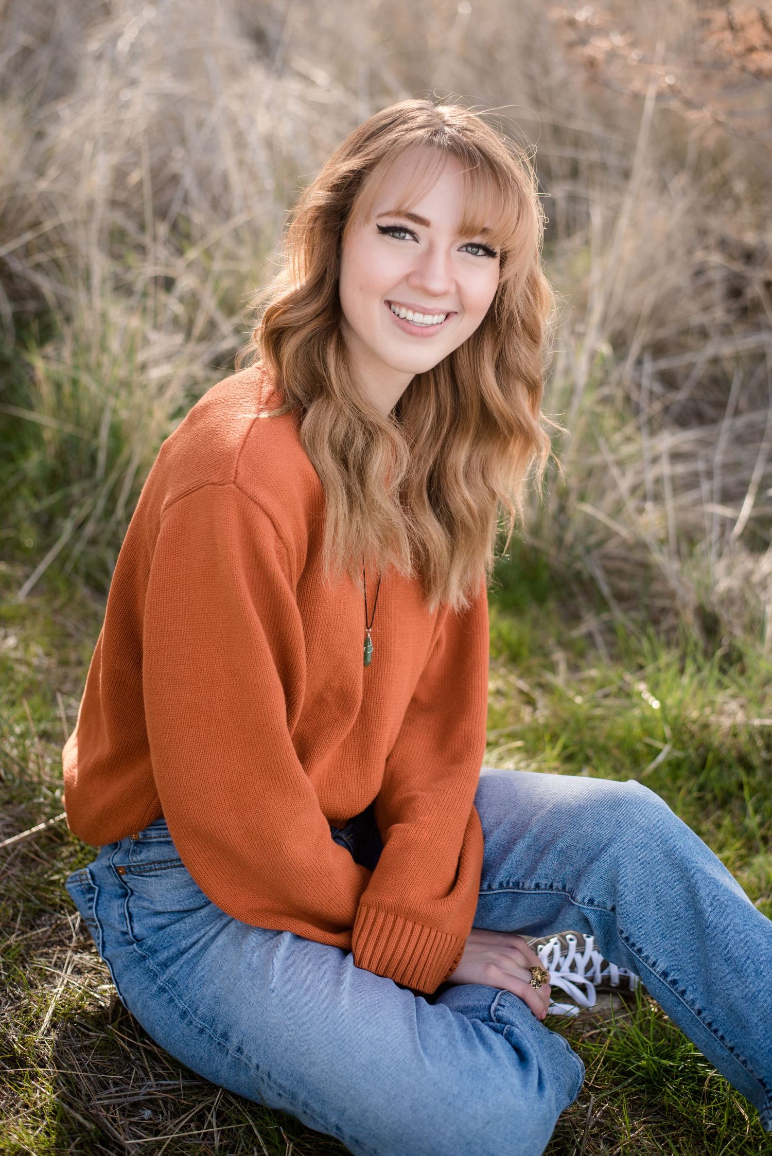 High school senior girl smiling during an outdoor senior photography session in Utah.