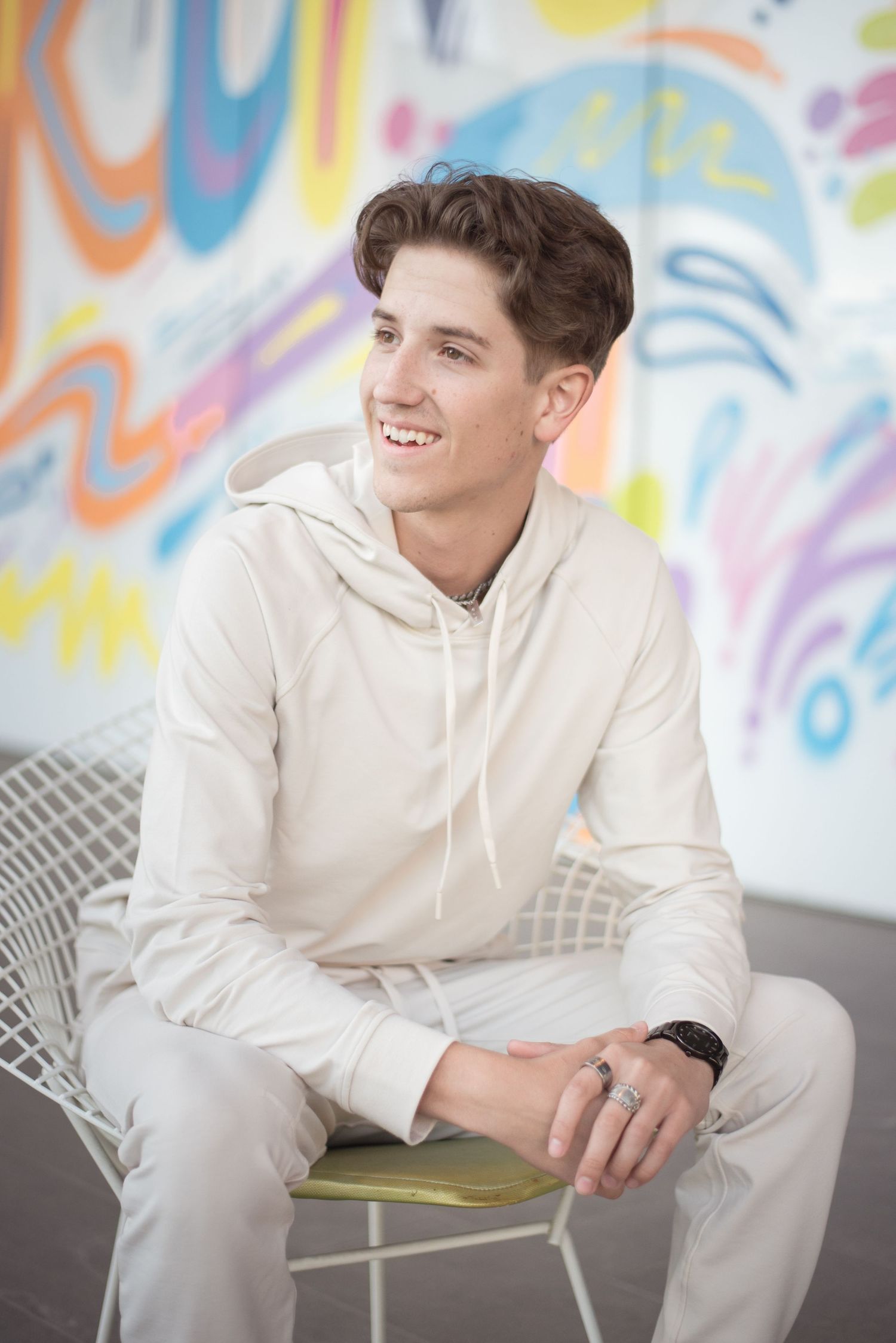 High school senior portrait featuring a young man posing in front of a colorful mural during an urban senior photography session in Provo.