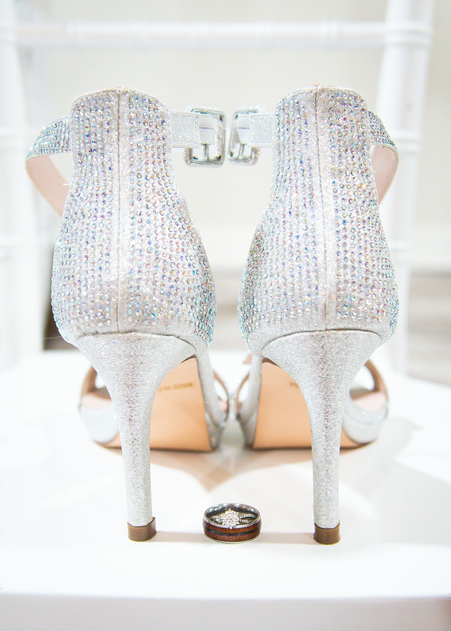 White bridal shoes photographed before a wedding ceremony with natural window light.