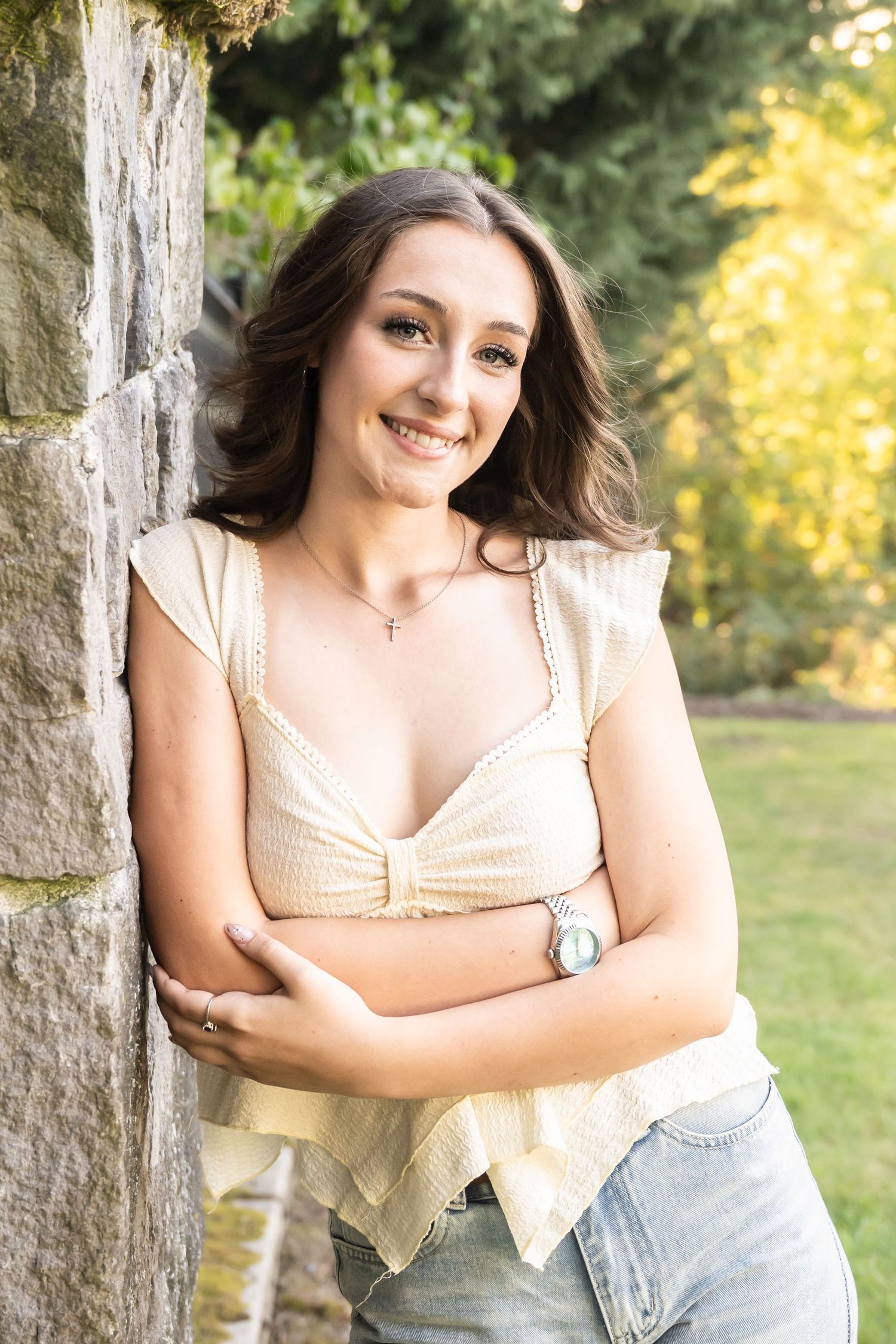 High school senior girl leaning against a tree during a warm golden hour outdoor senior photography session in Washington.