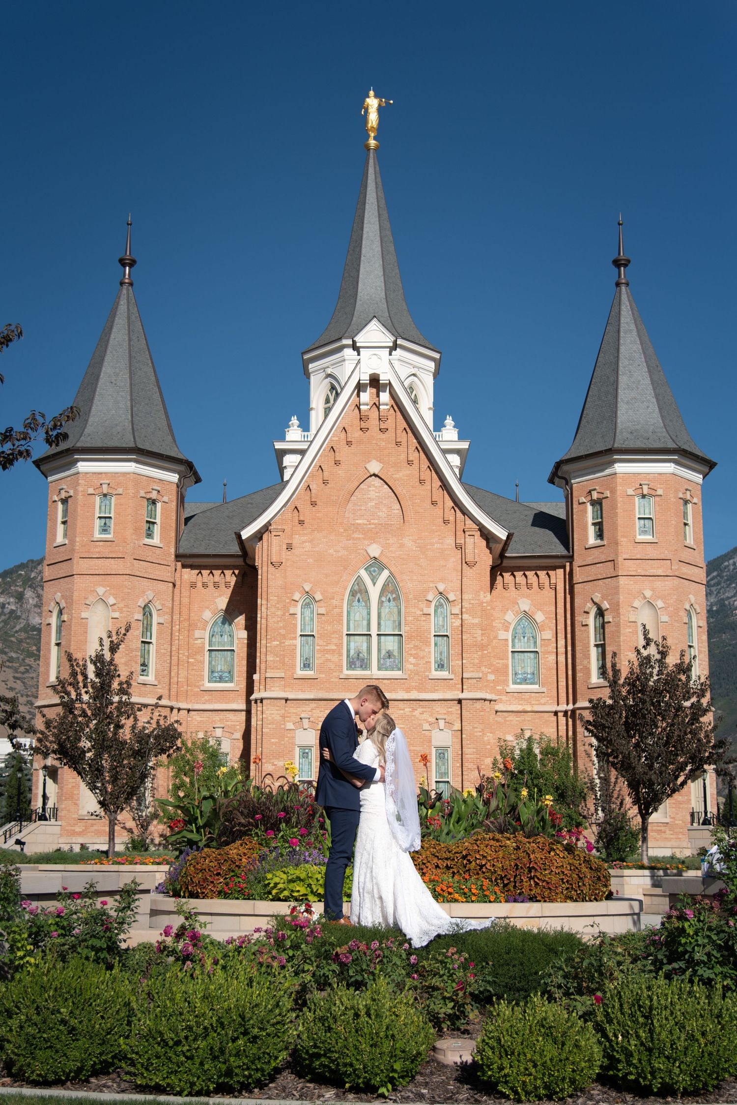 Bride and groom standing together in front of the temple during their wedding portraits.