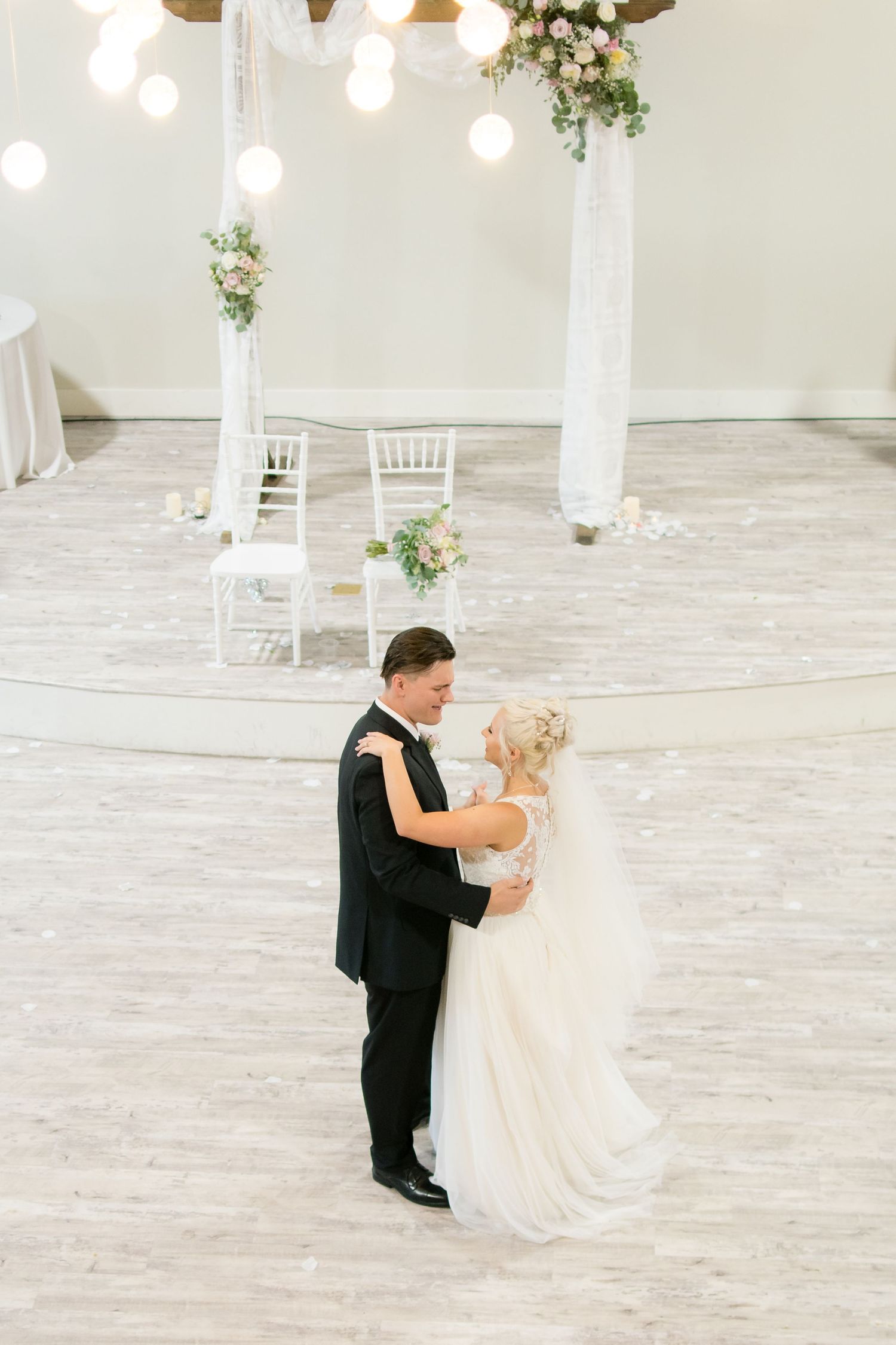 Bride and groom sharing their first dance during an elegant indoor wedding reception.