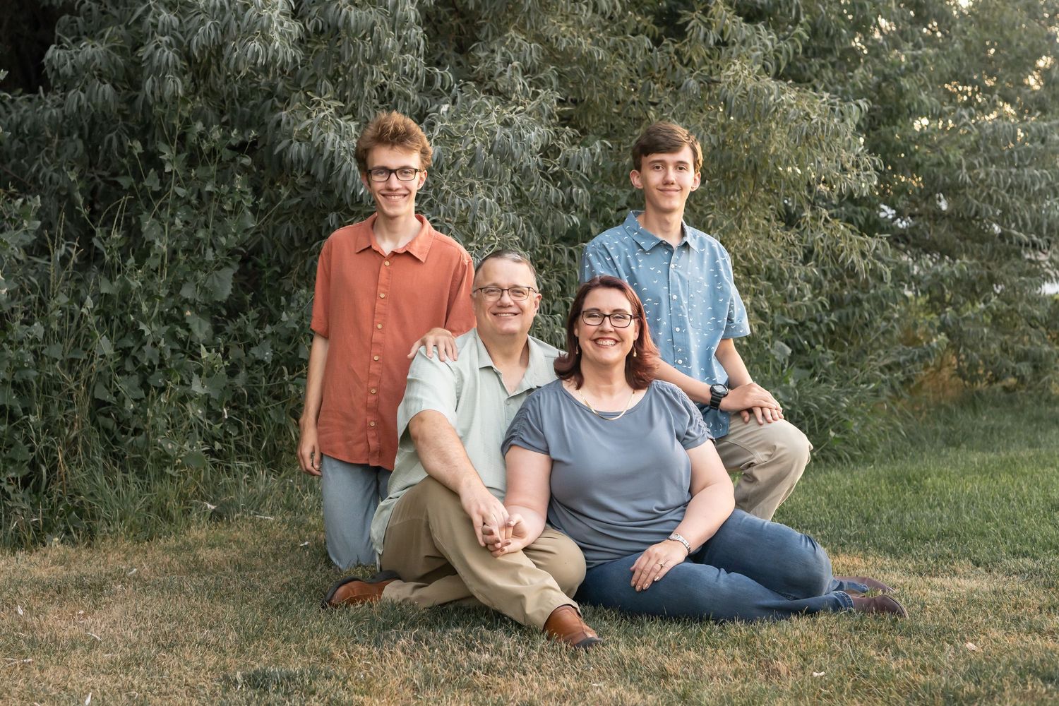 amily of four posing together during a relaxed outdoor family portrait session.