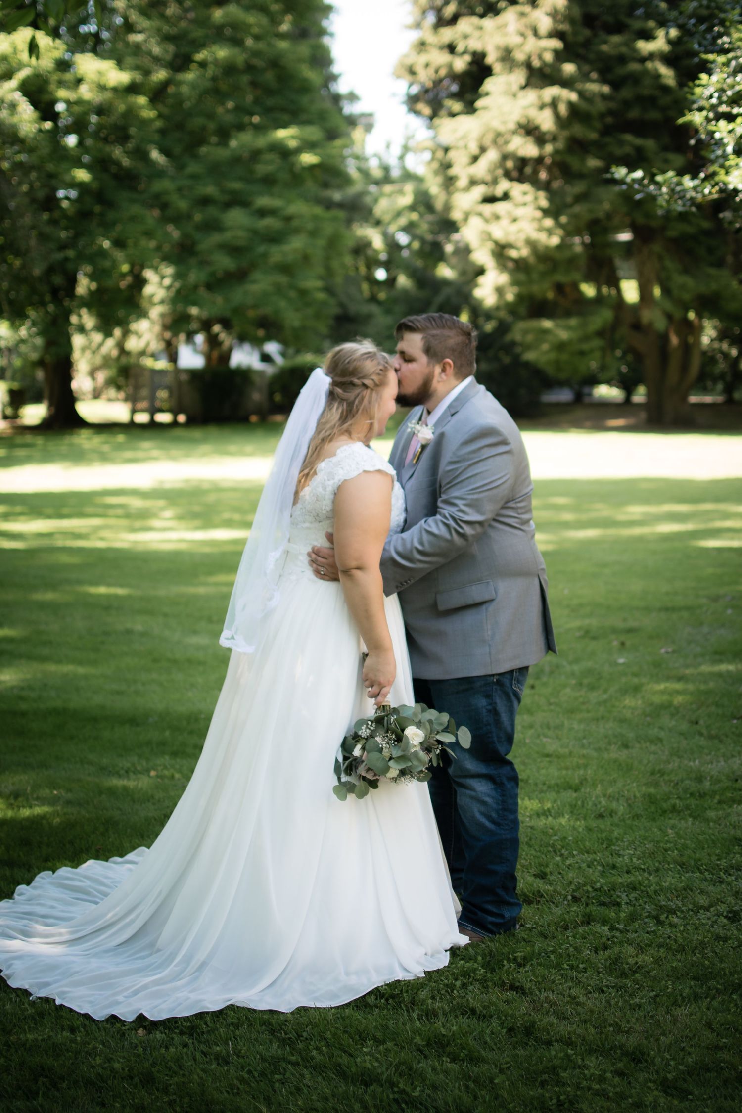 Bride and groom sharing a romantic embrace during an outdoor wedding portrait session.