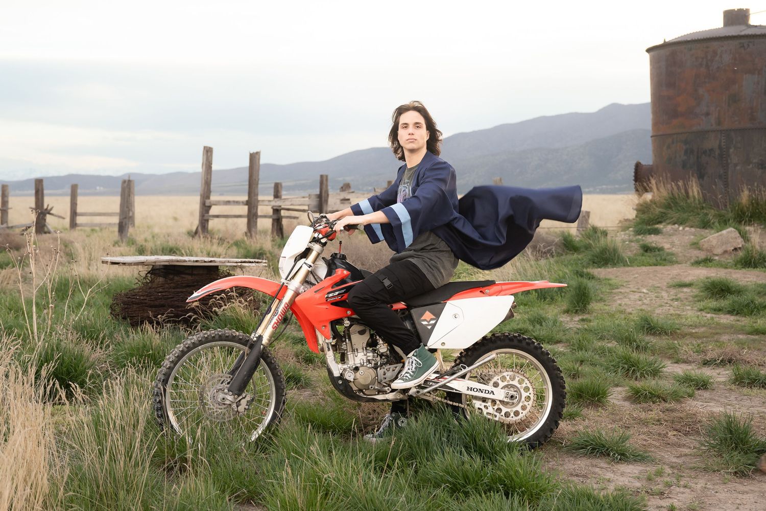 High school senior posing with a dirt bike in a scenic outdoor location during a personalized senior photography session in Utah.
