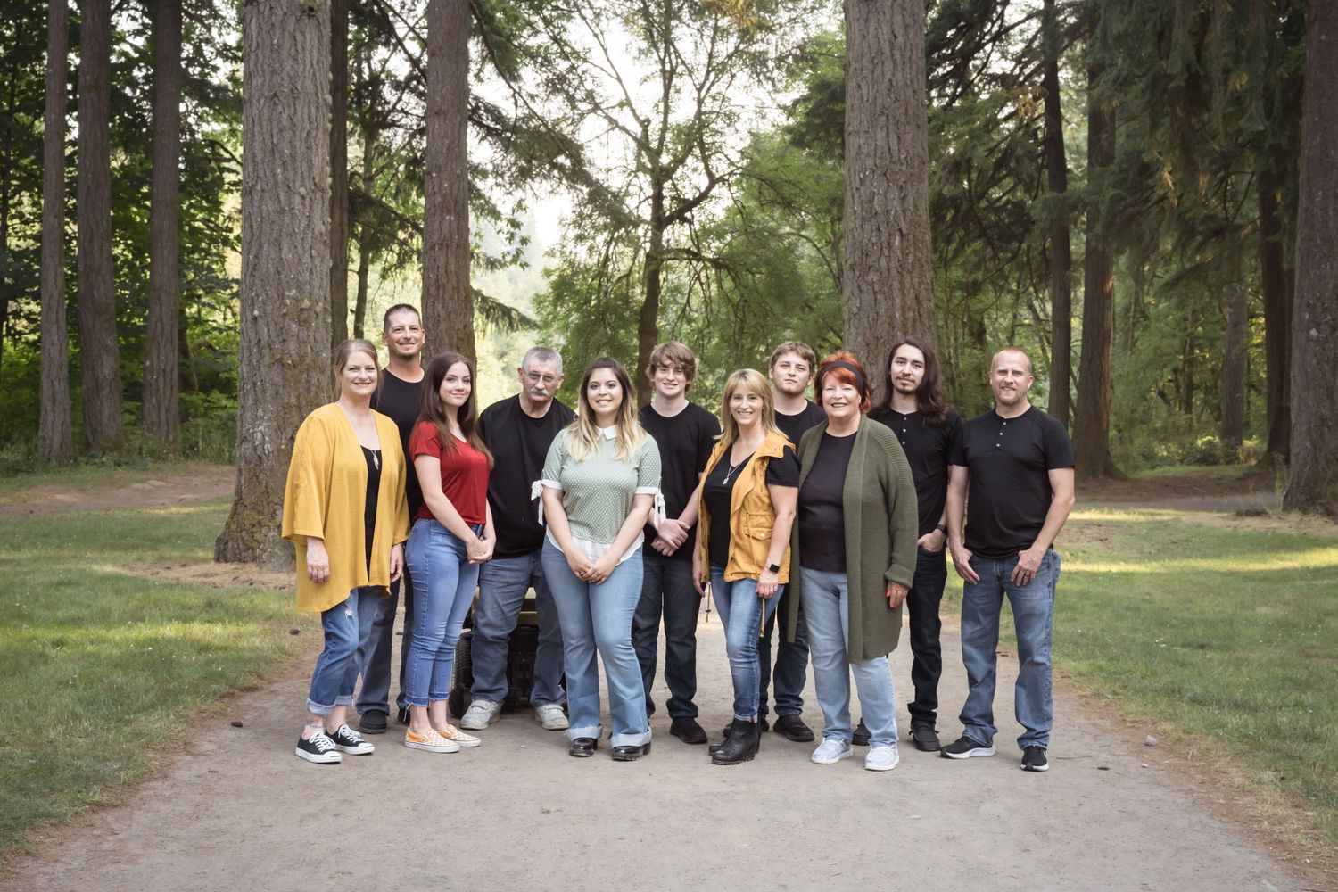 Natural light extended family portrait captured in a peaceful forest setting.