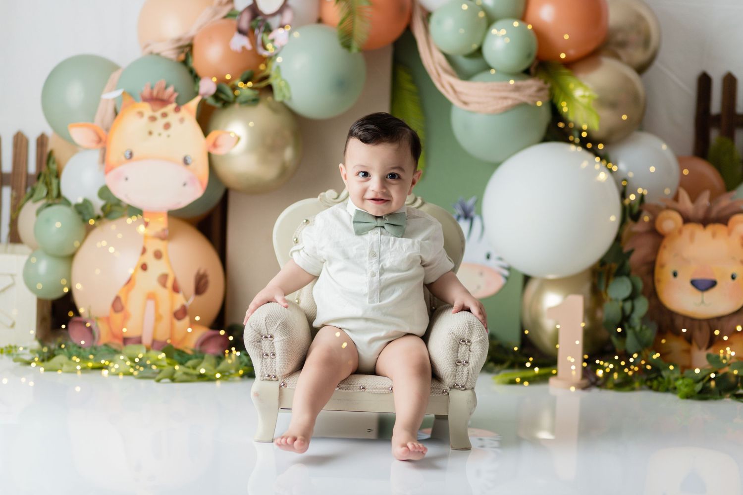 A pastel balloon arch with peach and mint colors creates a whimsical backdrop for a celebration setup.