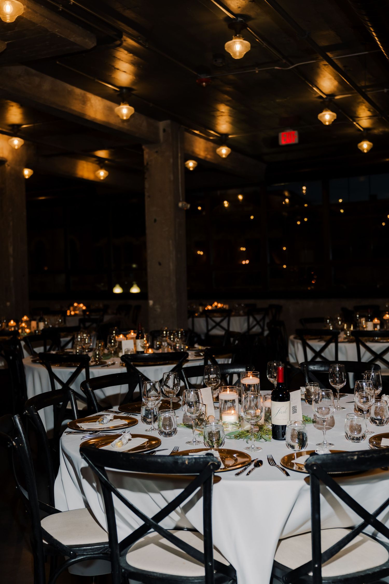 Elegant wedding reception tables set with white linens and candlelight.