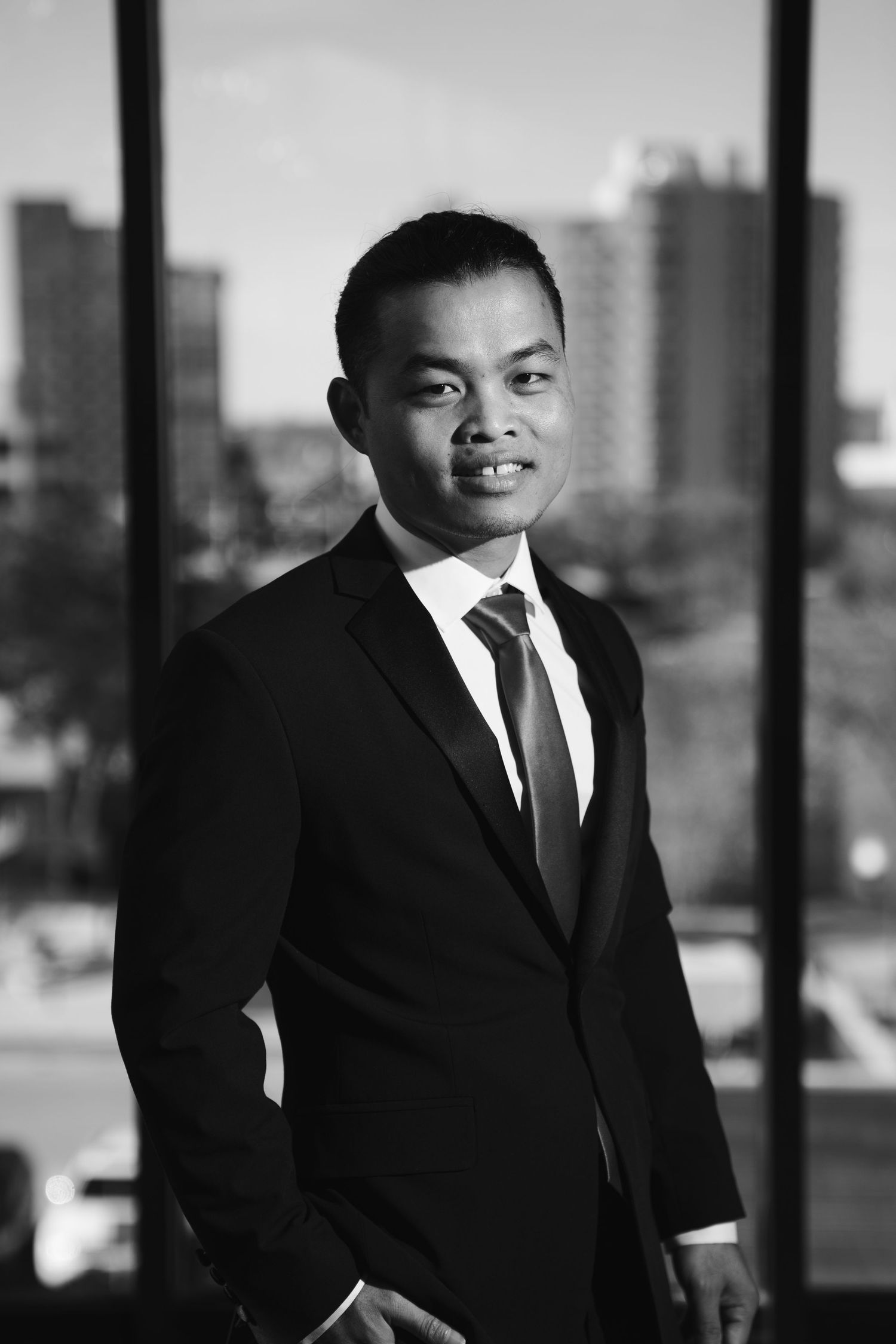 Professional portrait series in black and white showing a man in a suit against an urban backdrop.