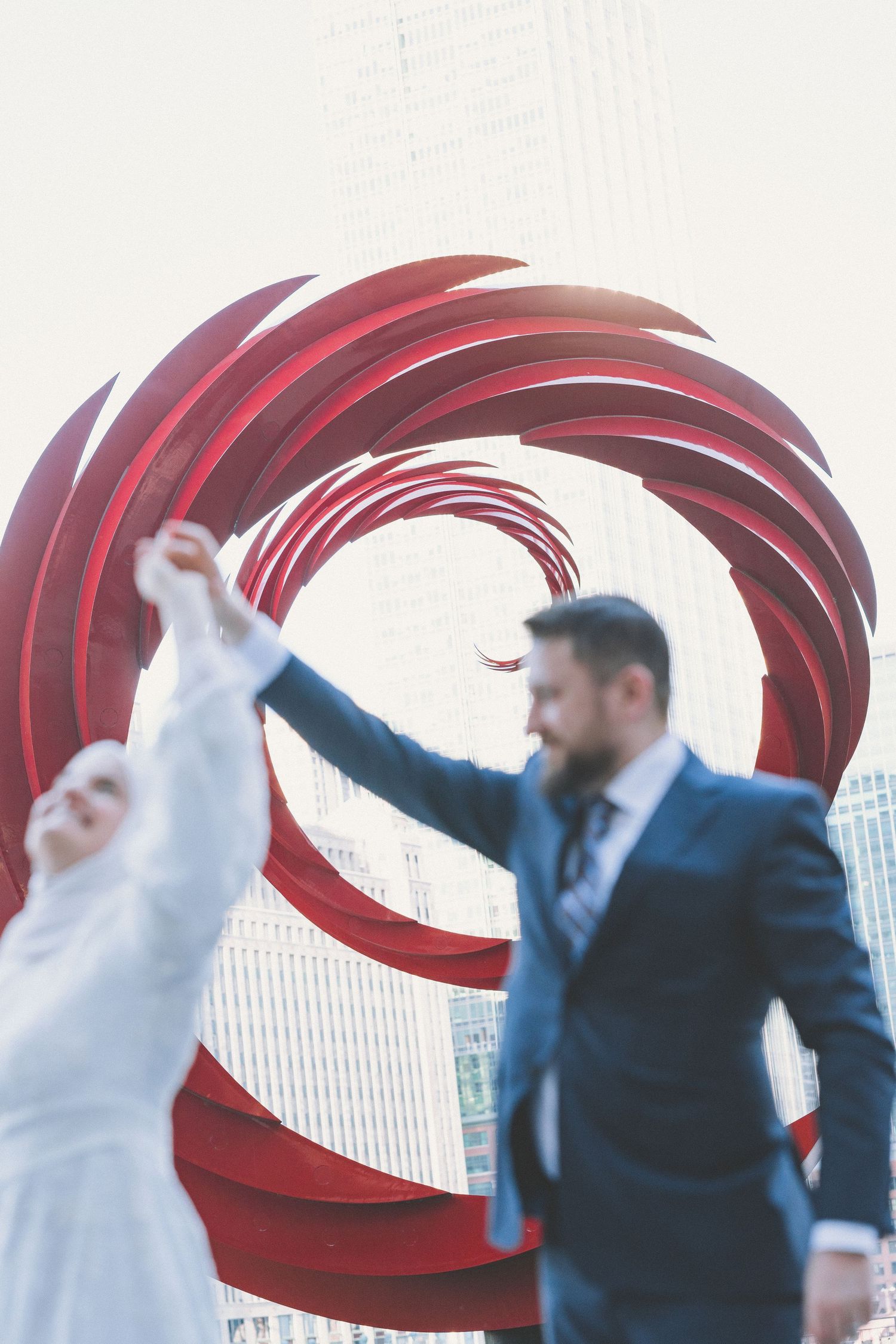 Abstract motion blur photo showing red swirls against white background with blurred figures.