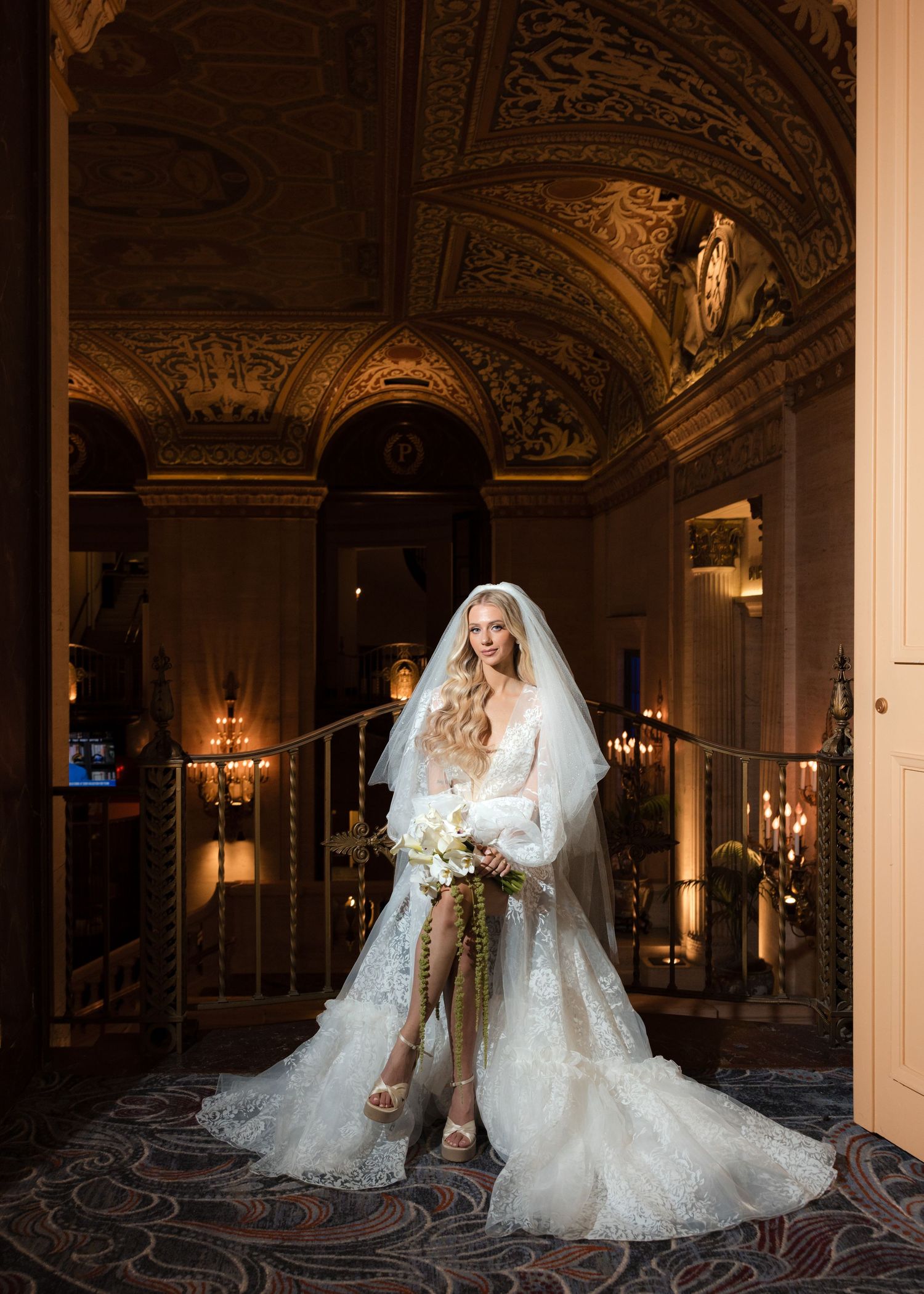 Bridal portraits in luxurious ballroom with ornate ceiling and chandeliers.