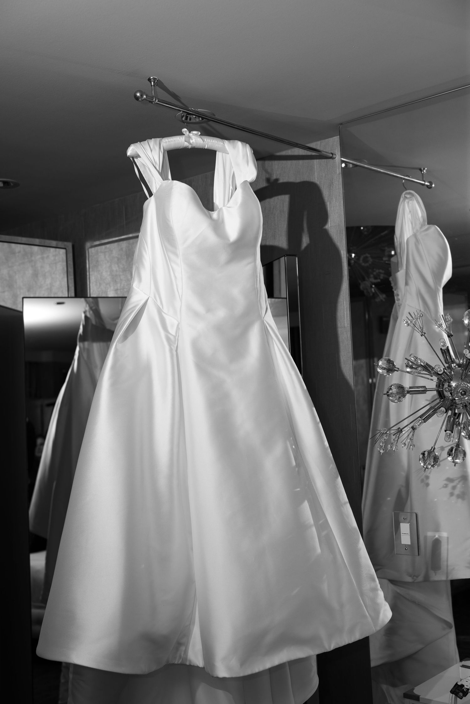 White wedding dresses displayed on hangers in a bridal boutique showroom.