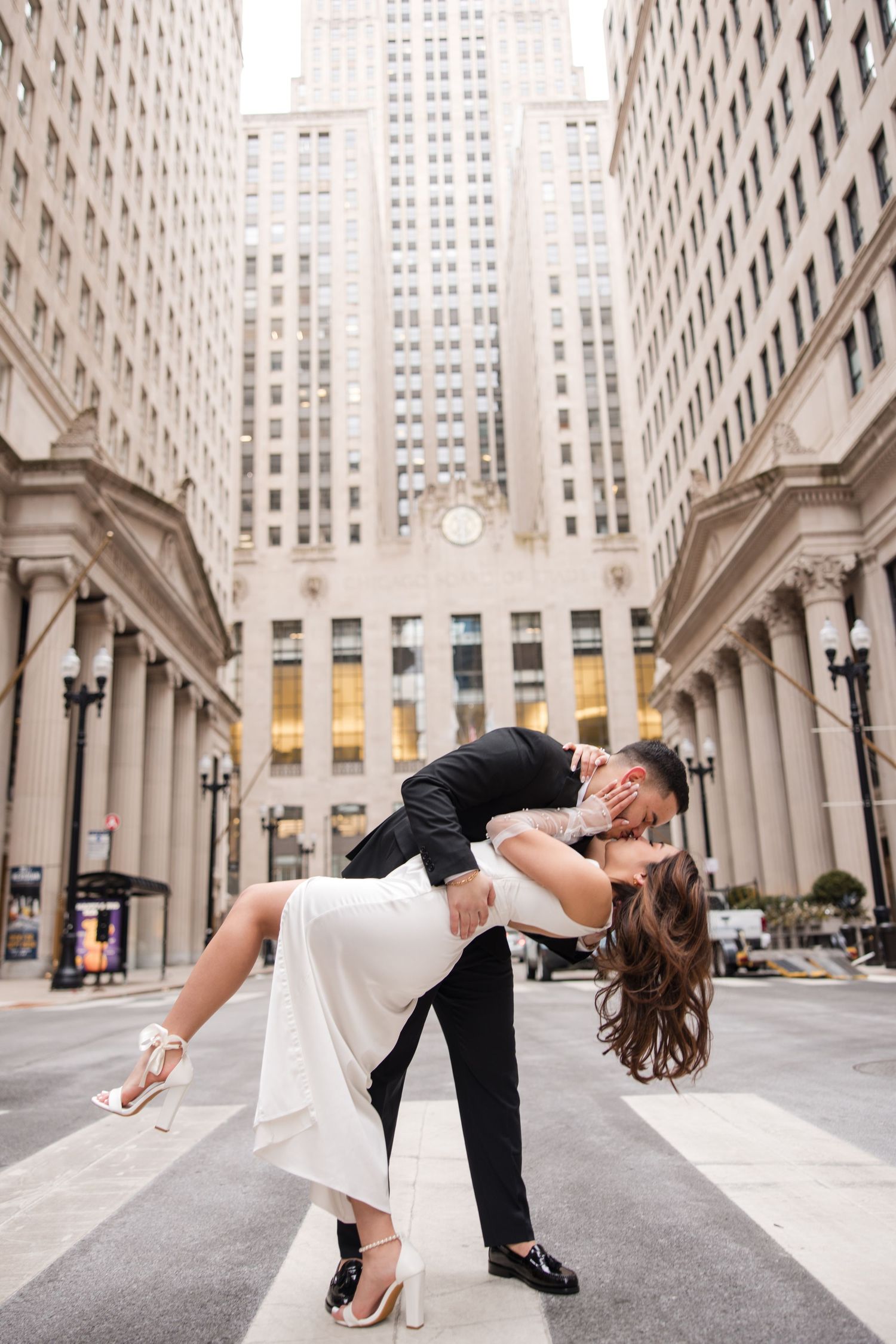Romantic dip pose in front of classic Chicago architecture building.