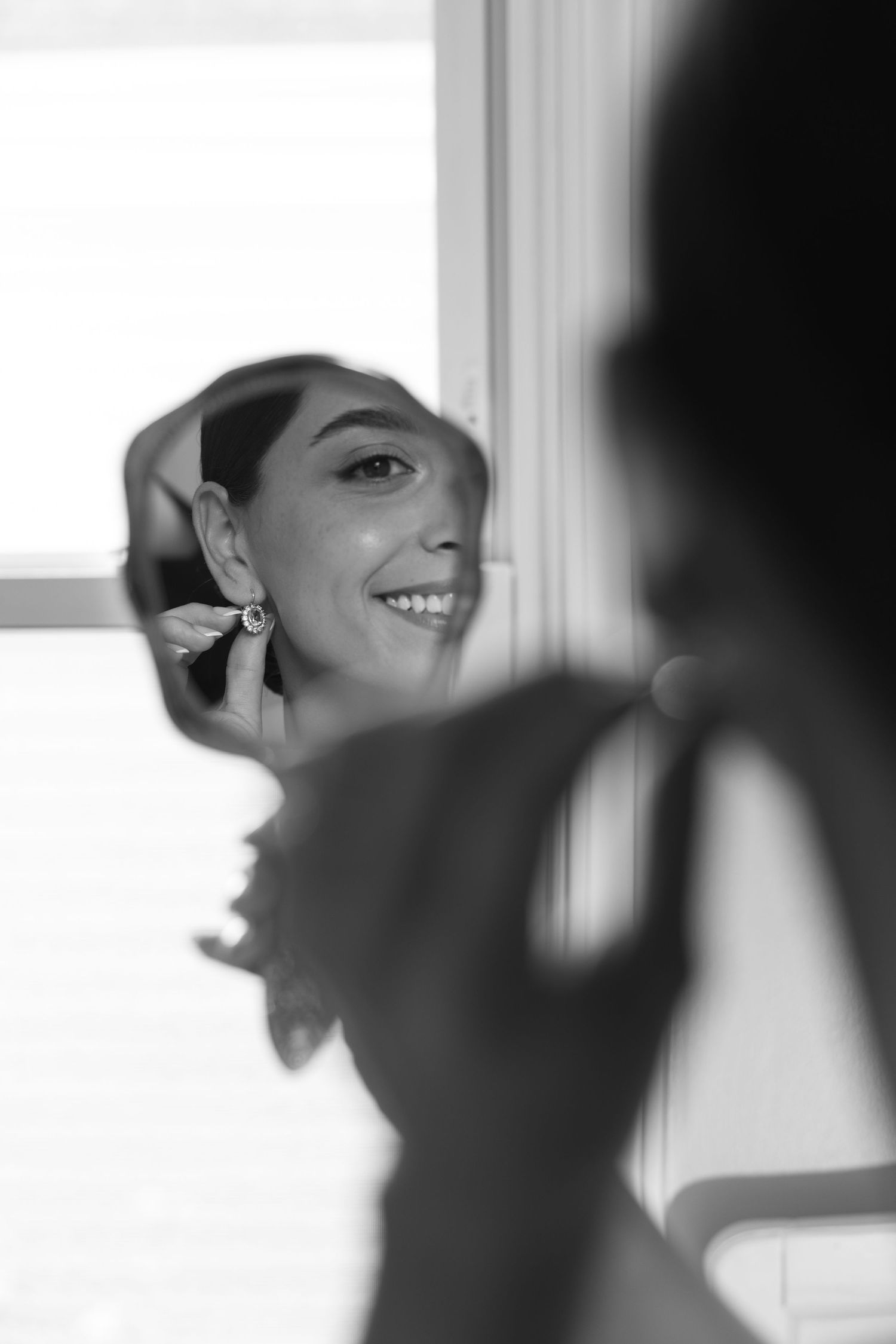 Black and white reflection of getting ready moment in mirror.