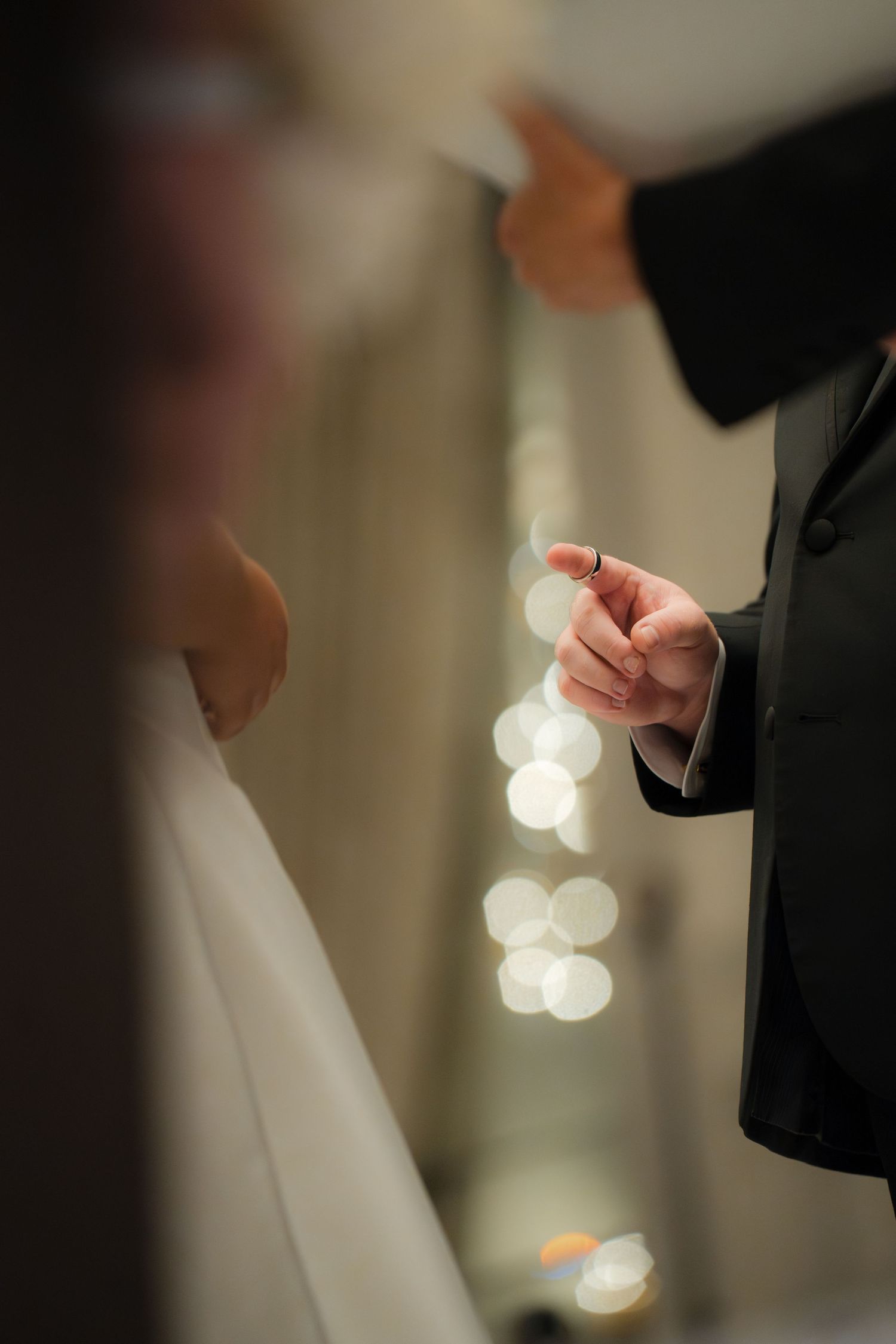 Close-up details of hands during an intimate wedding ceremony moment.