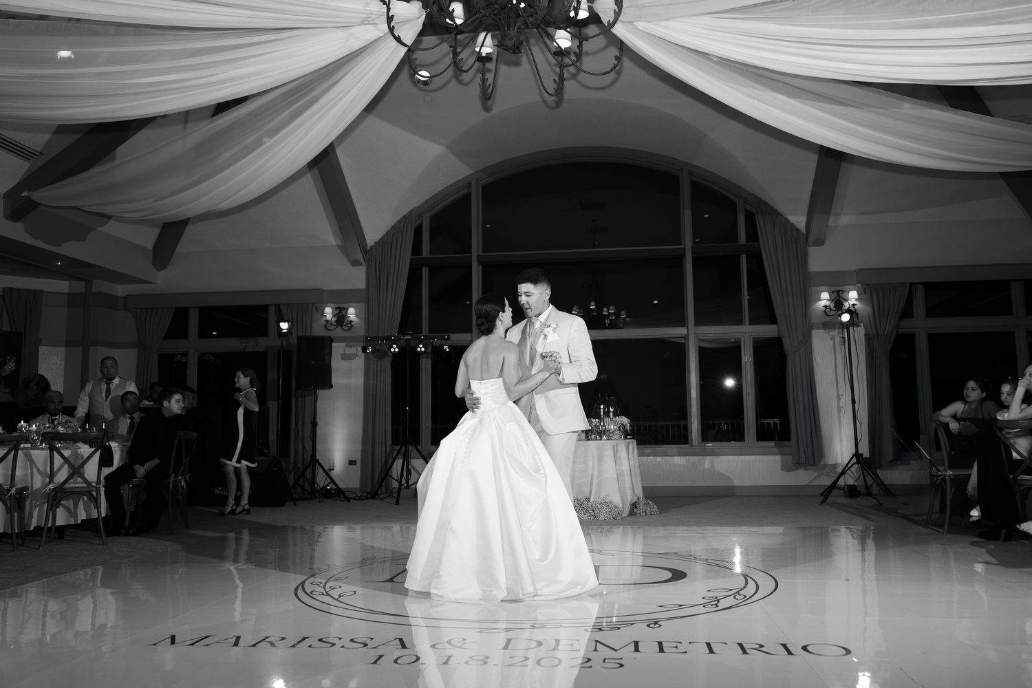 Wedding reception venue with white fabric draping and elegant lighting creating a romantic atmosphere.