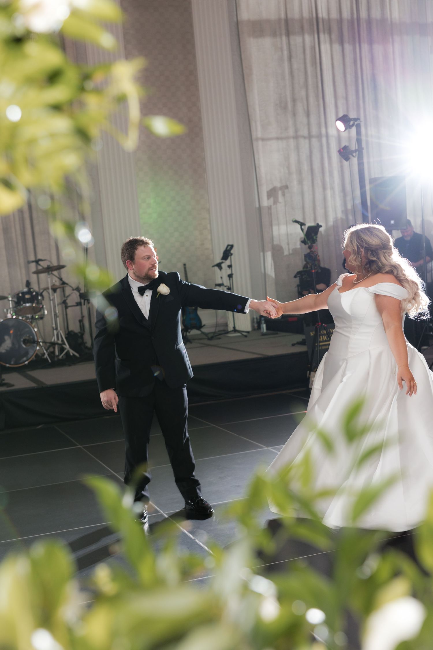 Couple performs romantic first dance in elegant ballroom setting.