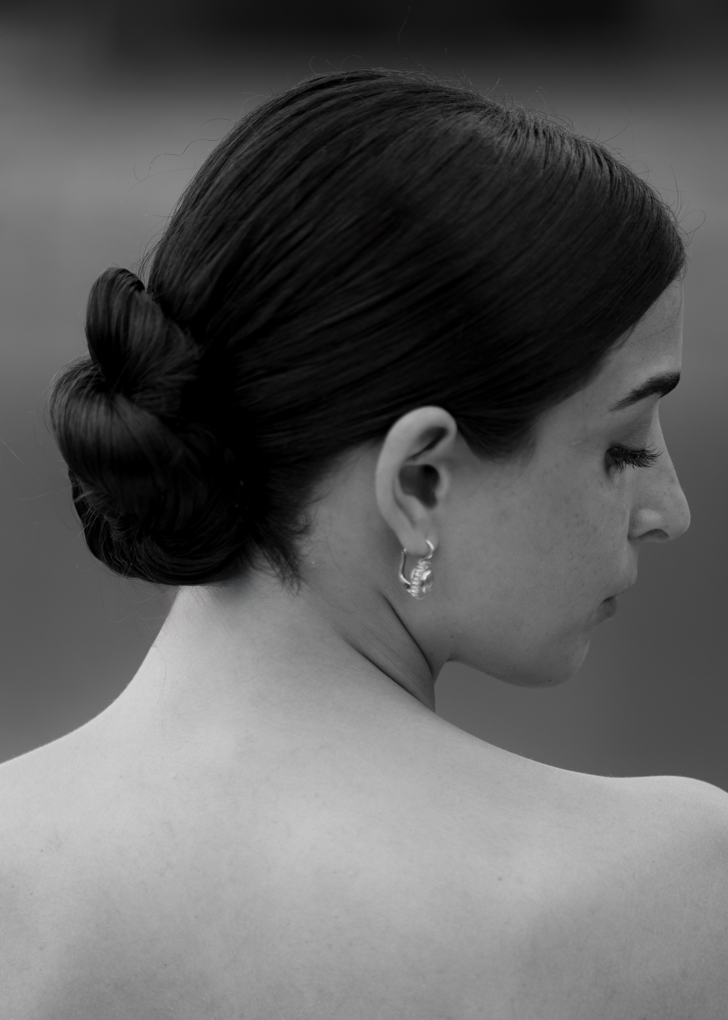 Black and white close-up portraits showing an elegant updo hairstyle with delicate earrings from multiple angles.