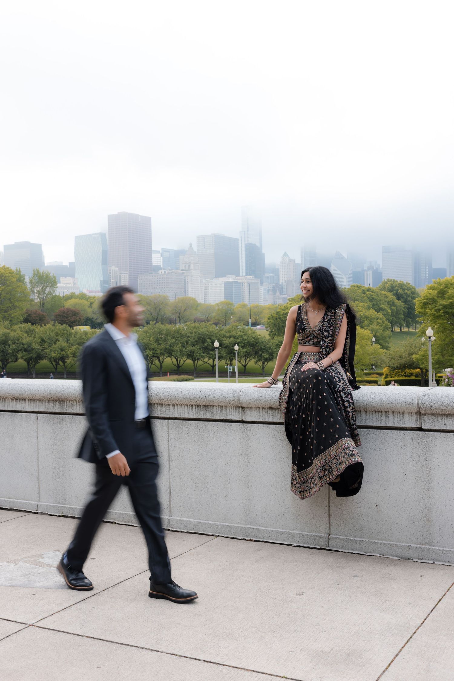 Artistic engagement photos on rooftop with urban skyline views.
