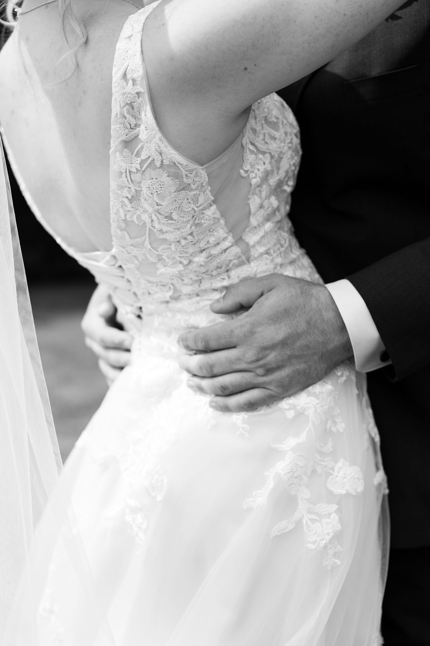 Close-up details of white lace wedding dress bodice in black and white.