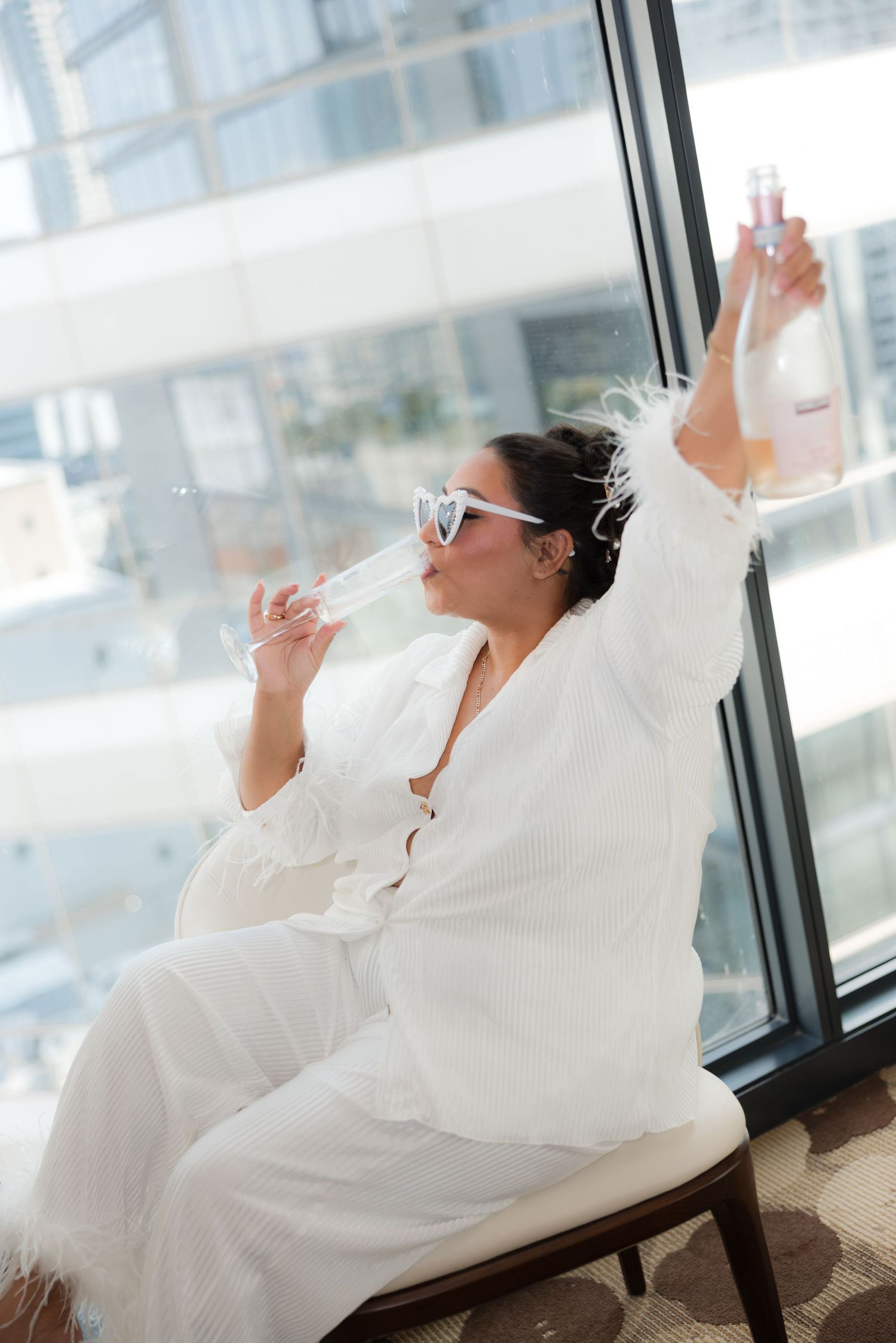 Person in white robe relaxing by window in sunlit room with dramatic poses.