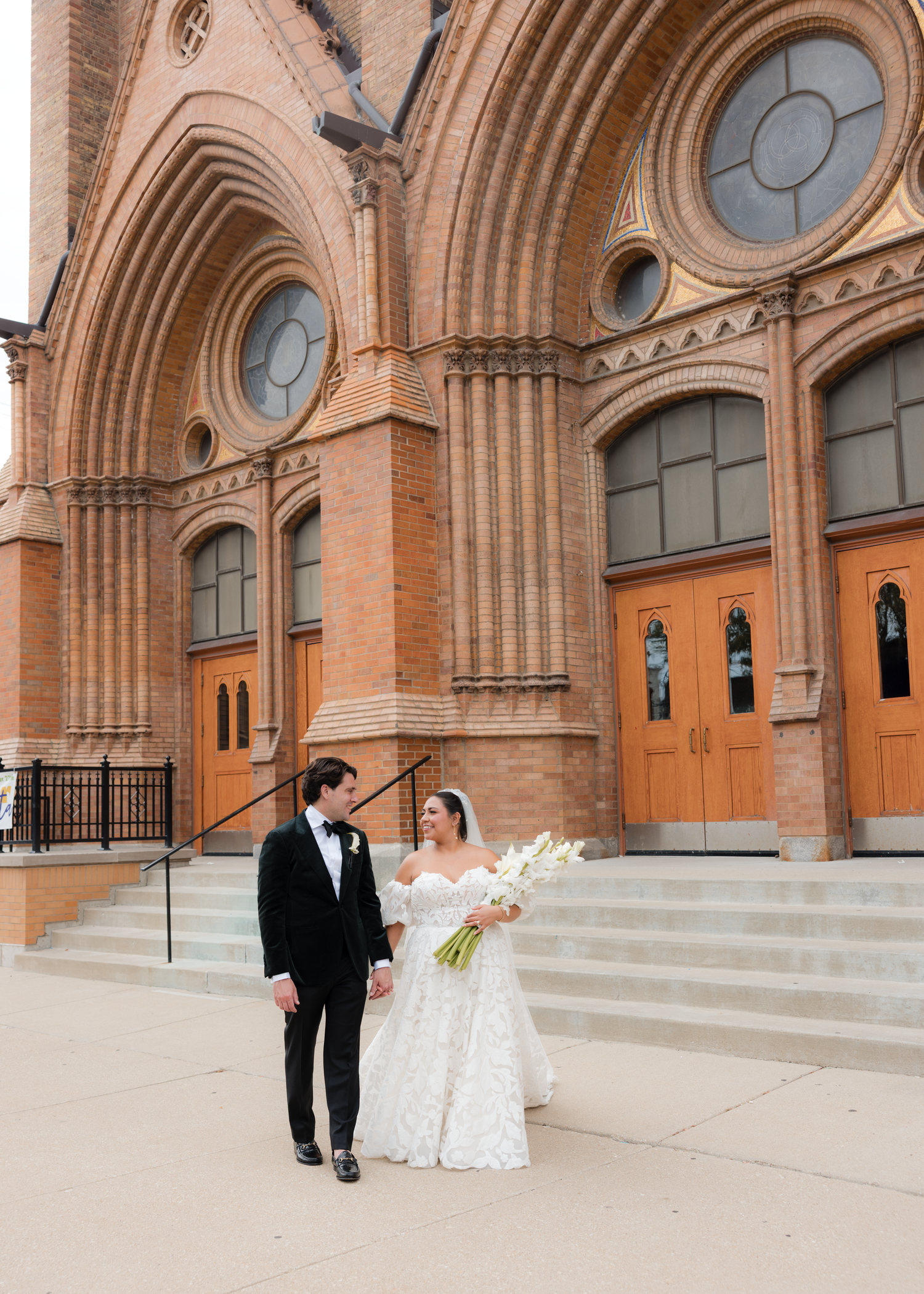 Gothic church exterior with arched doorways and steps where a wedding ceremony took place.