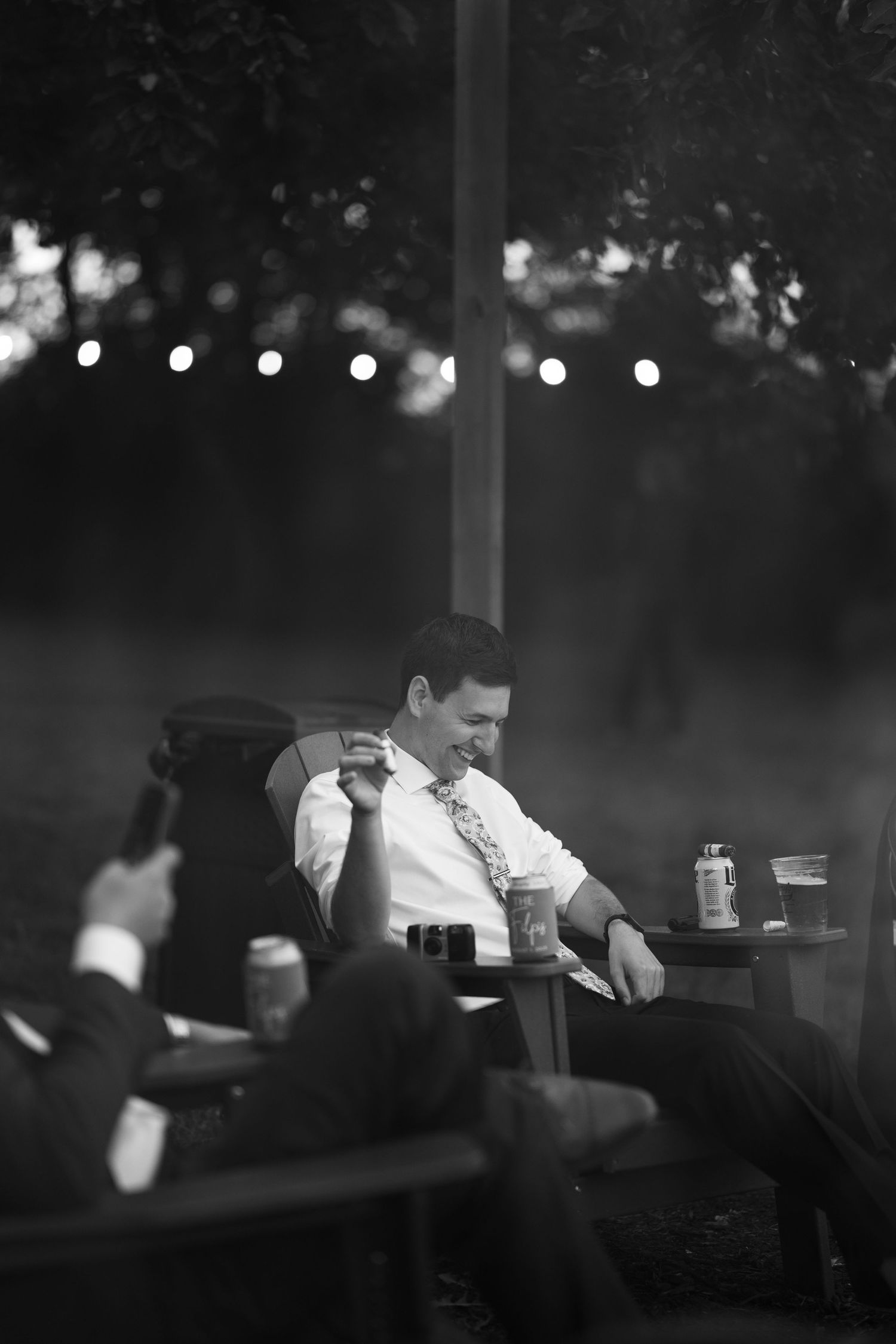 Moody black and white reception scene with string lights creating ambient atmosphere.