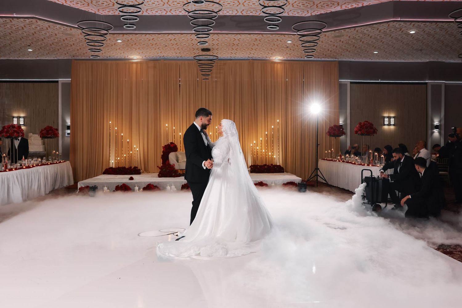 Wedding reception hall decorated with dramatic lighting and fog effects.