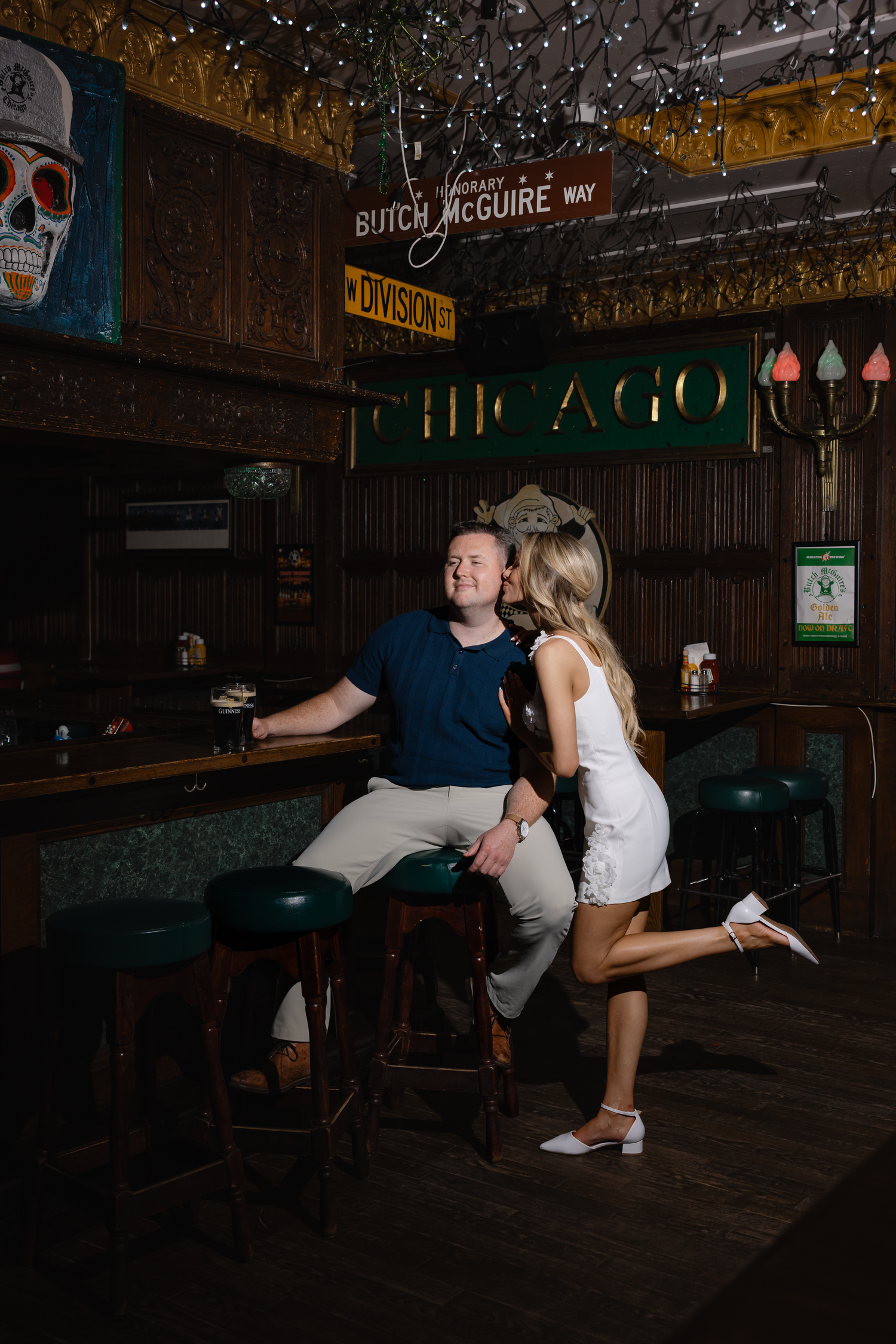 Couple sharing a romantic moment at Butch McGuire's bar in Chicago, woman in white dress kissing man's cheek.