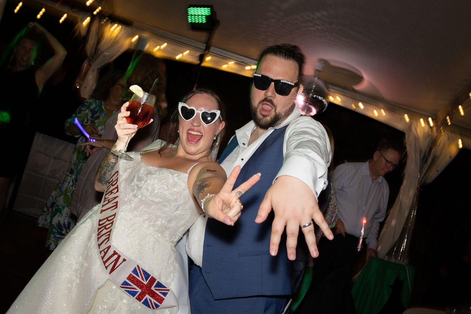Wedding reception dance party with colorful lighting and energetic atmosphere.