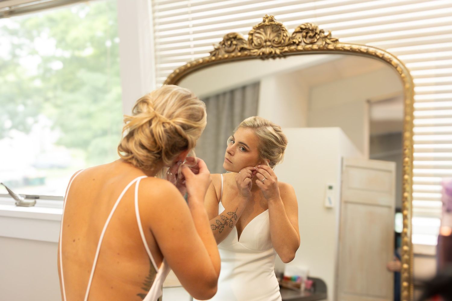 Bridal preparation scene with natural window light in getting ready room. Wedding