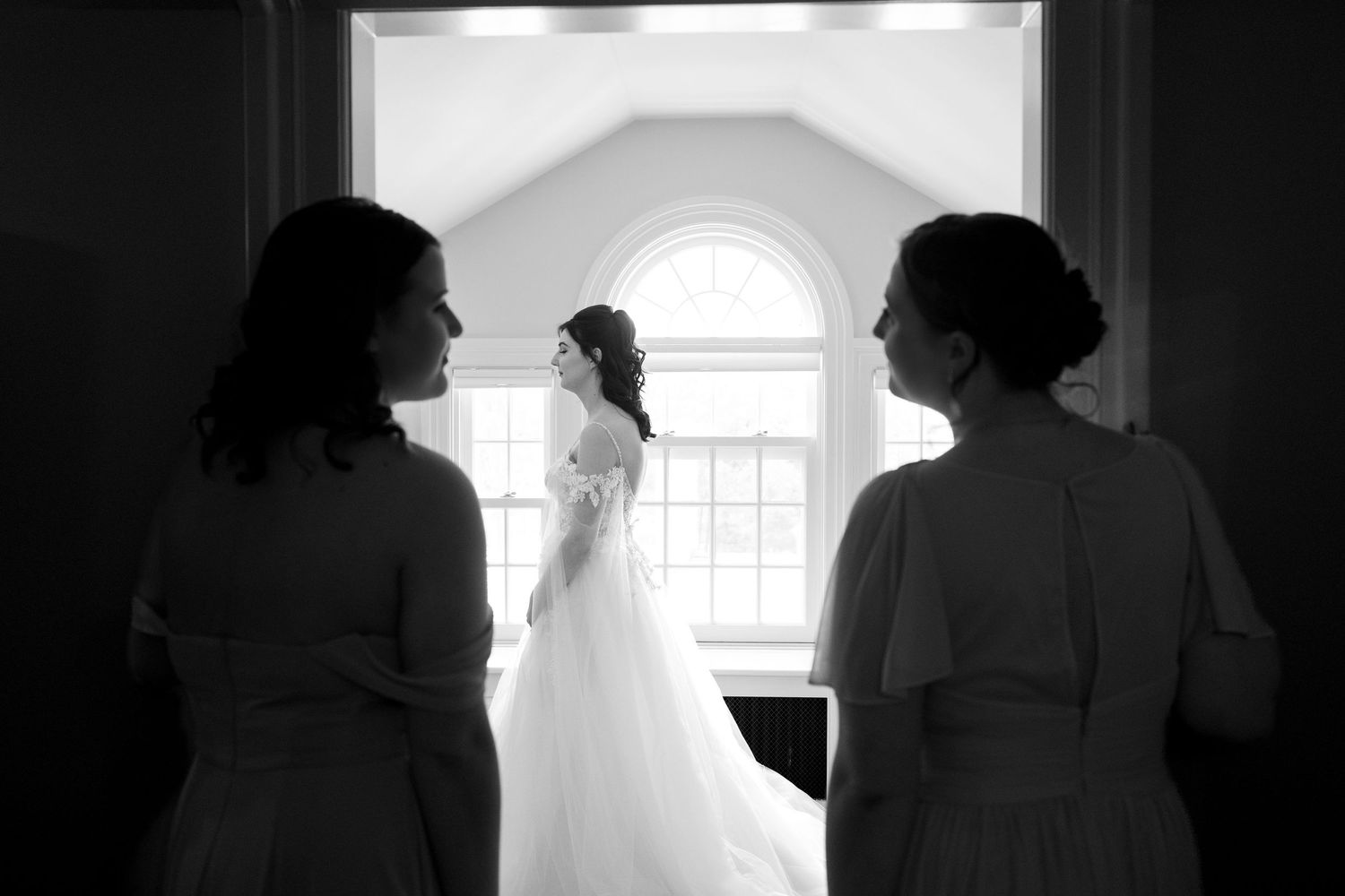 A series of silhouetted figures in window frames creating a dramatic black and white composition.