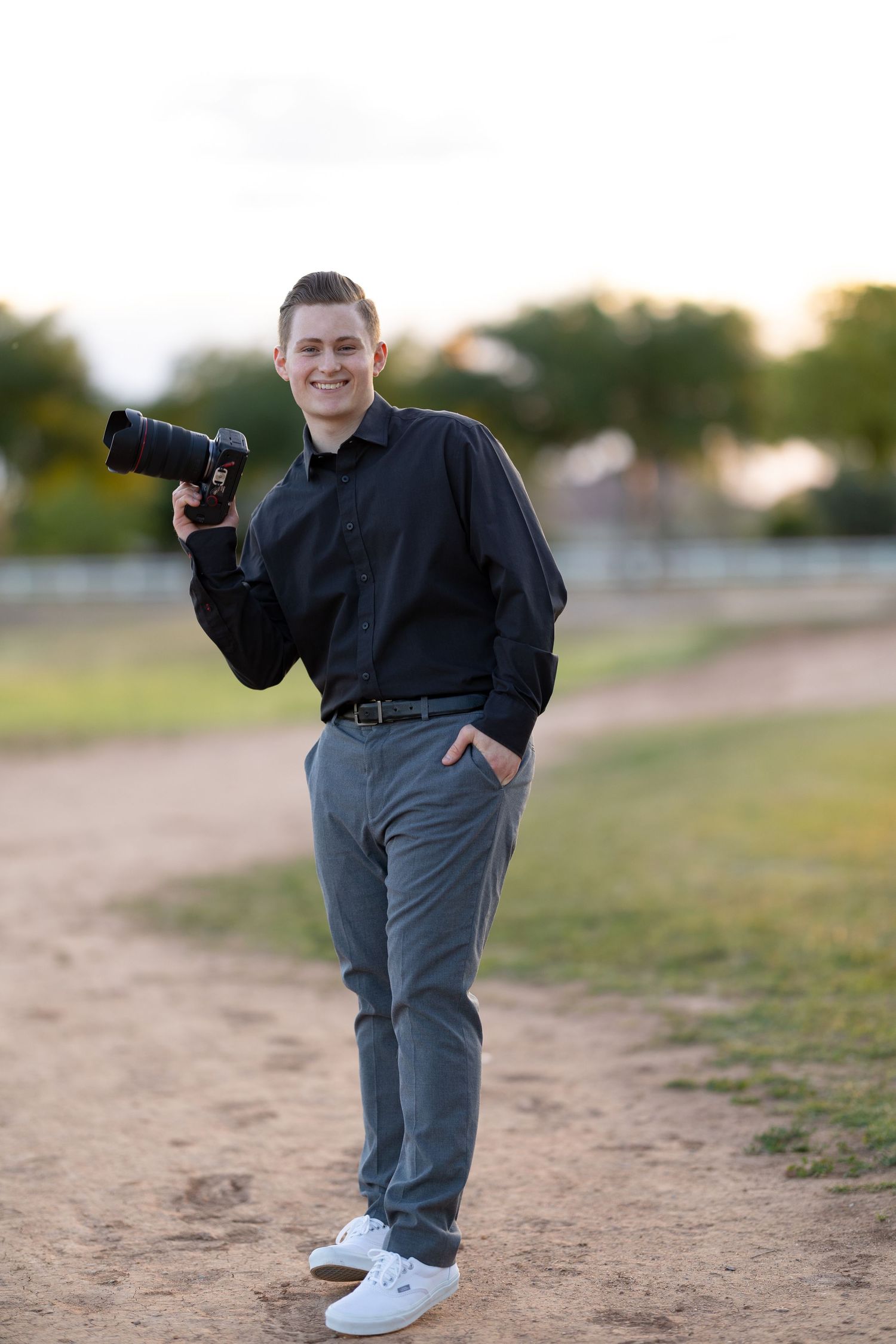 Jayden Sanford Photo business portrait holding camera while laughing.