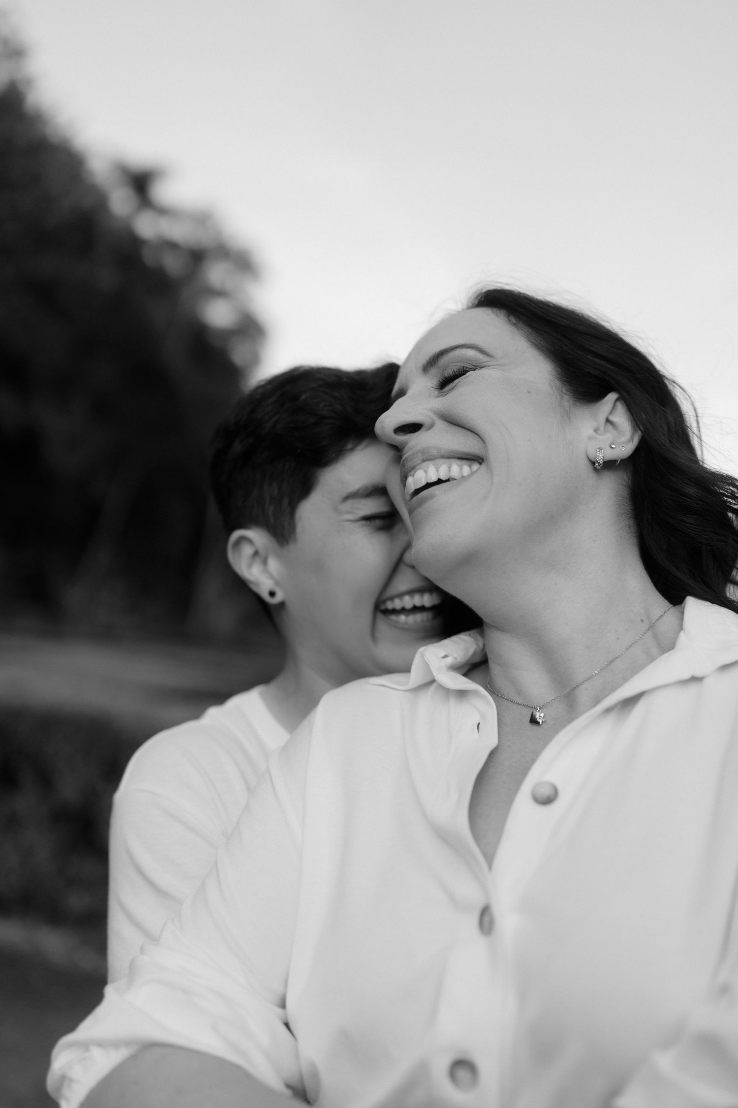 A black and white photo series showing a couple in white clothing sharing joyful intimate moments together.