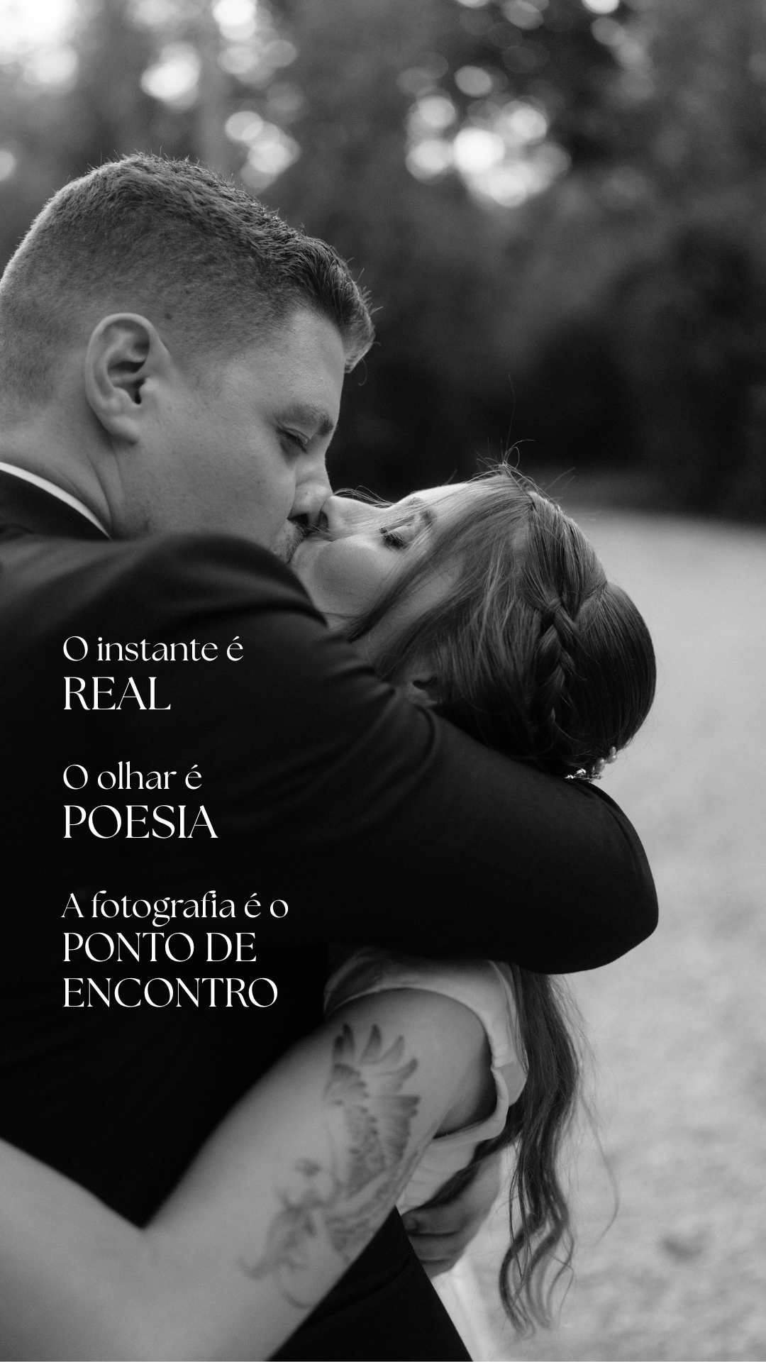 Black and white romantic couple embracing and kissing in a tender moment outdoors.